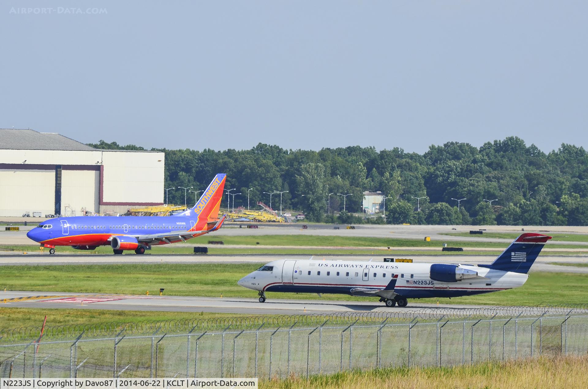 N223JS, 2004 Bombardier CRJ-200ER (CL-600-2B19) C/N 7892, US Airways Bombardier CL-600 waits for a Southwest Airlines 737-3H4 (N618WN) to pass at Charlotte International Airport on June 22, 2014.