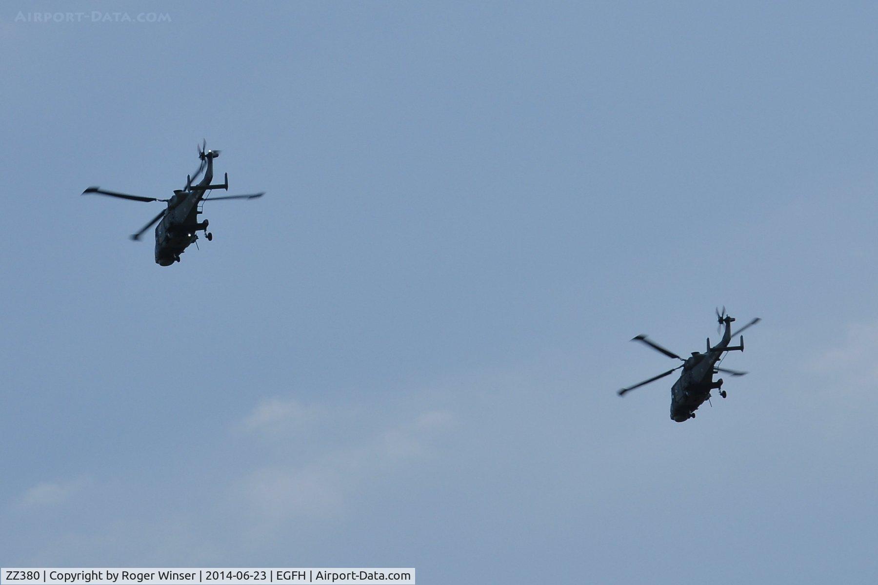 ZZ380, 2013 AgustaWestland AW-159 Wildcat HMA.2 C/N 499, Leading Talon formation overhead the airport. Operated by 700W NAS based at HMS Heron (RNAS Yeovilton). The second Wildcat helicopter could be ZZ375.