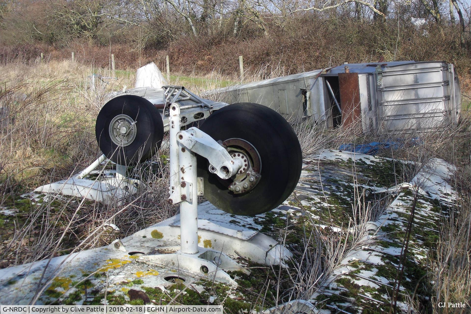 G-NRDC, 1981 NDN NDN-6 Fieldmaster C/N 004, The upturned wing and undercarriage section dumped at Sandown, Isle of Wight, close to the main airframe. The aircraft remnant in the background is an unidentified/anonymous Fieldmaster engineering mock-up.