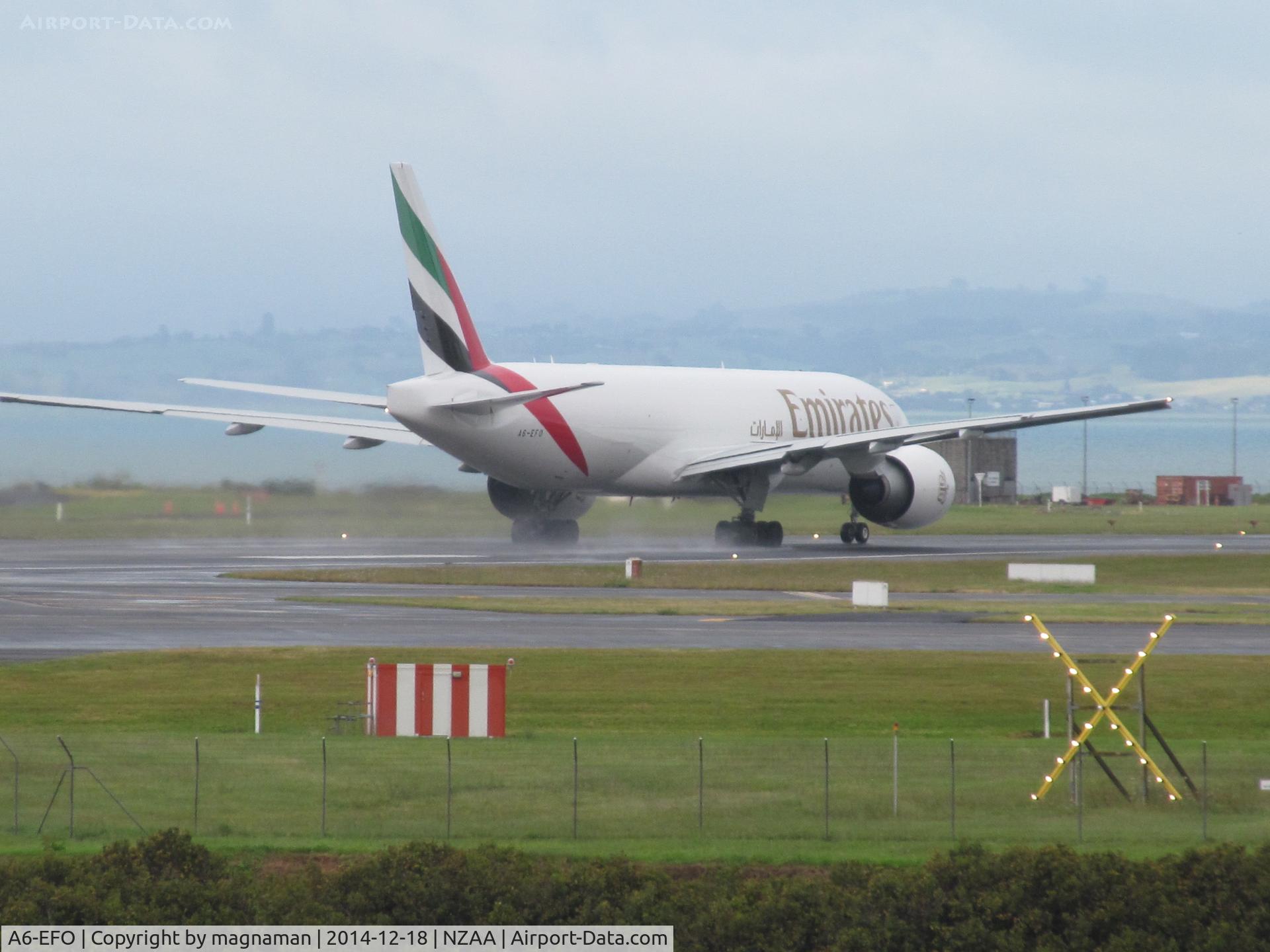 A6-EFO, 2014 Boeing 777-F1H C/N 42233, departing on wet runway