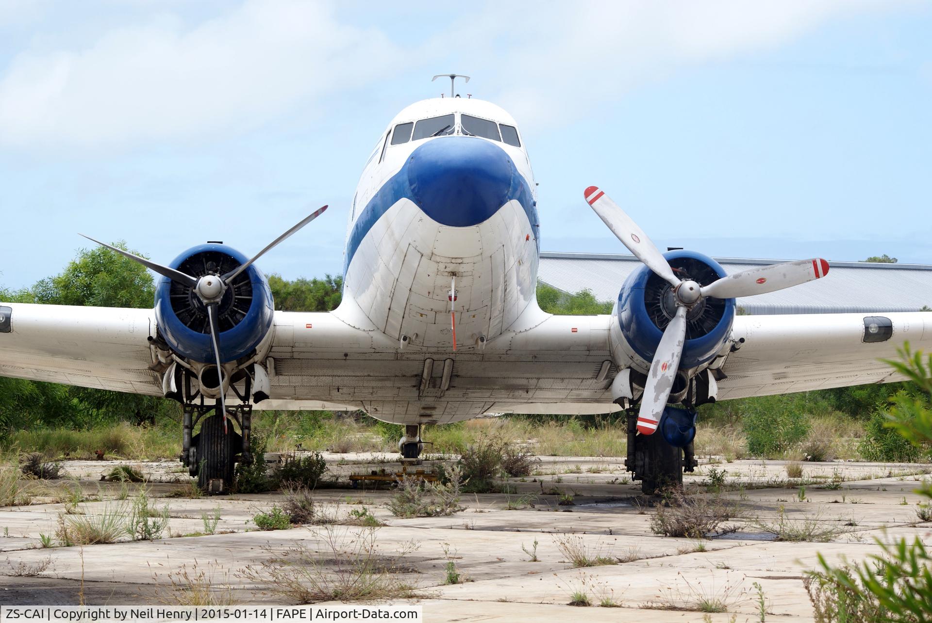 ZS-CAI, 1944 Douglas C-47A Skytrain (DC-3C-47A-25-DK) C/N 13541, Parked in a work area of PLZ airport next to a hangar.  It appears that the port engine is missing parts and under refurbishment.  Informant said it had previously been in a film and had its identity changed to suit - hence markings in Arabic on side
