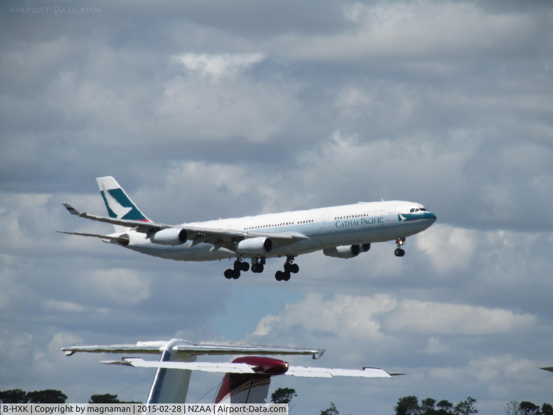 B-HXK, Airbus A340-313 C/N 228, landing at NZAA - long shot in heat haze over convair apron
