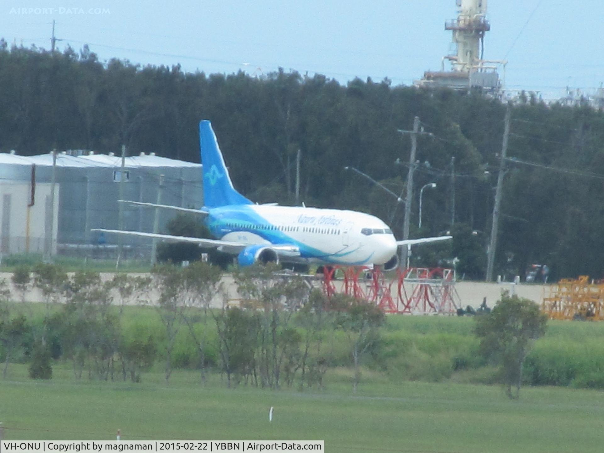 VH-ONU, 1998 Boeing 737-3U3 C/N 28732, at YBBN awaiting next flight - long distance view from international terminal