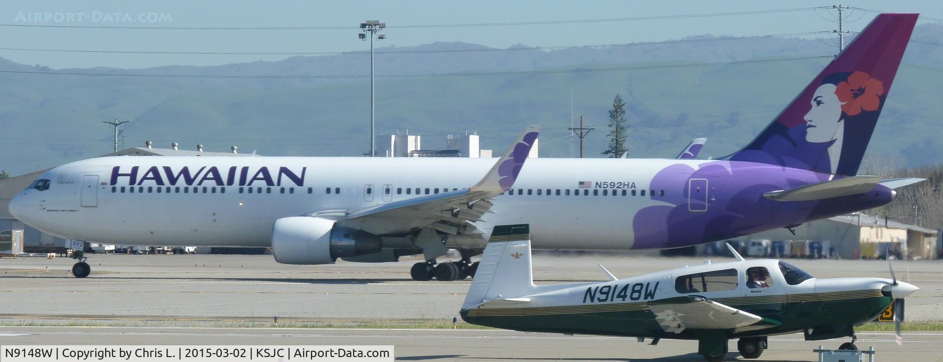N9148W, 1991 Mooney M20M Bravo C/N 27-0106, A 1991 Mooney M20M back taxing for a full length while a Hawaiian Airlines 767-300 with winglets departs to Honolulu.