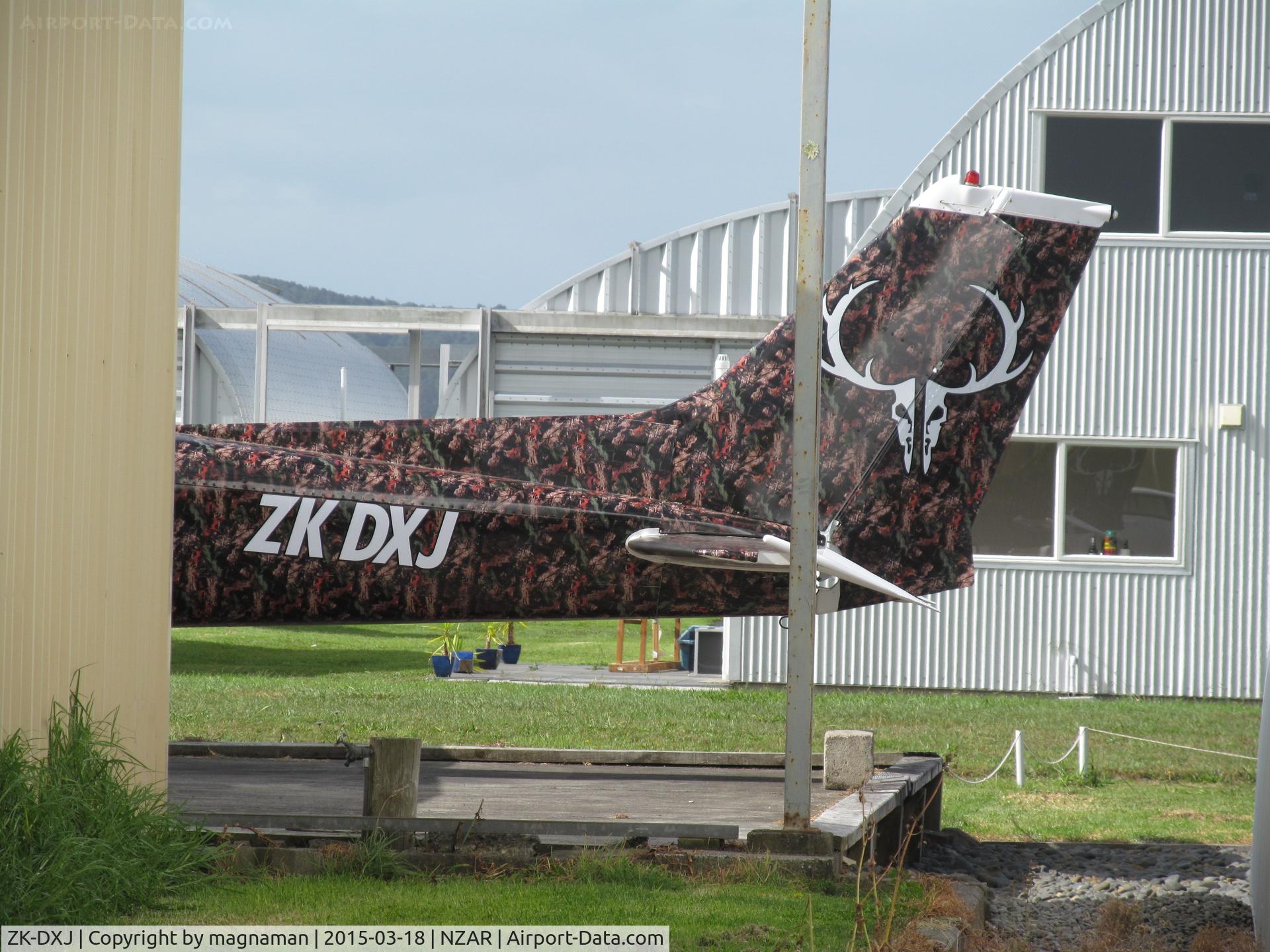 ZK-DXJ, Cessna 172M C/N 17265810, spotted between hangars with what looks like a newly painted reg and fancy background!!