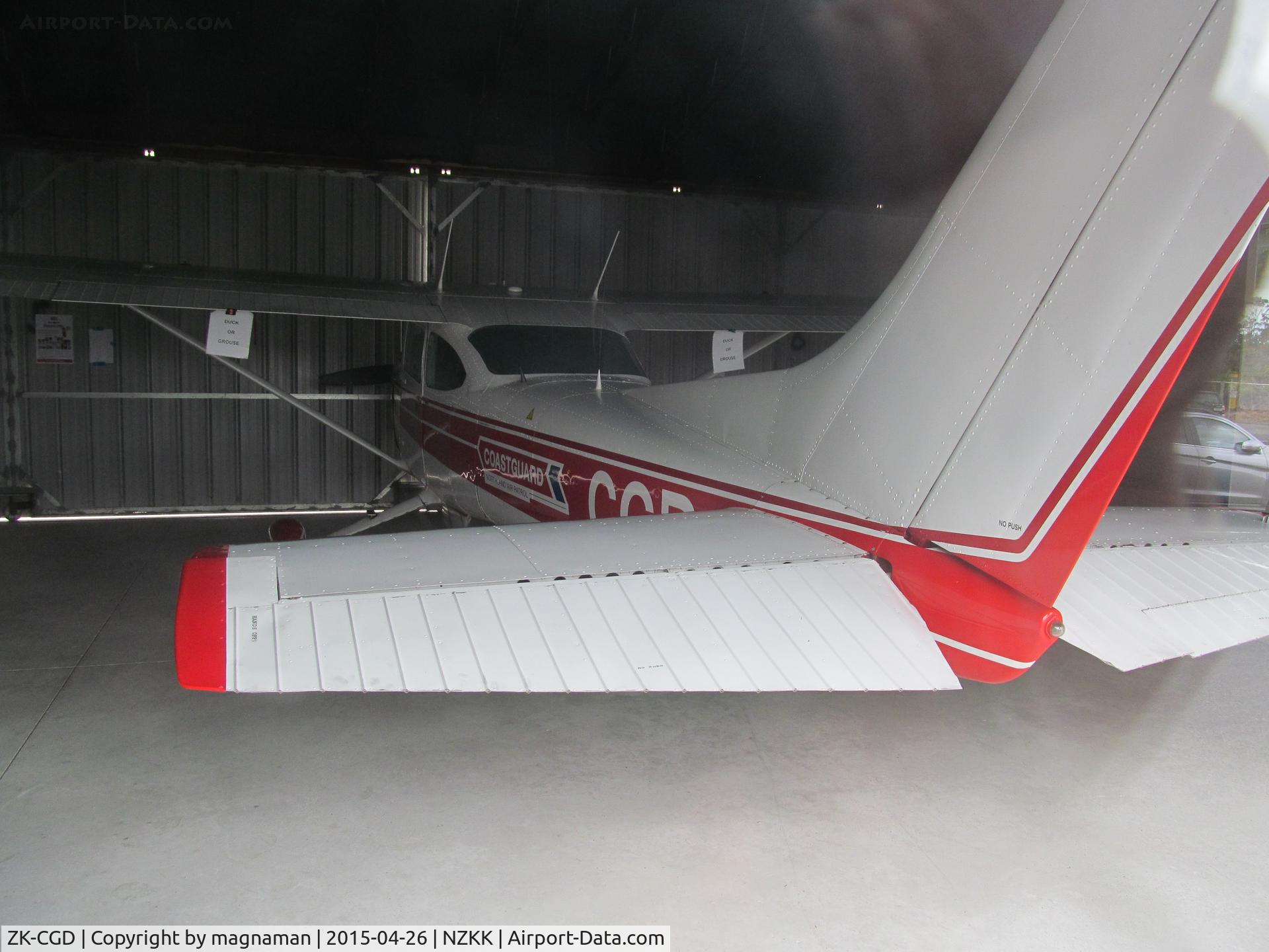 ZK-CGD, Piper PA-28-151 C/N 28-7715223, Not a PA28 but Coastguard Cessna - in glass walled hangar at KeriKeri base. Viewed through window from car park.