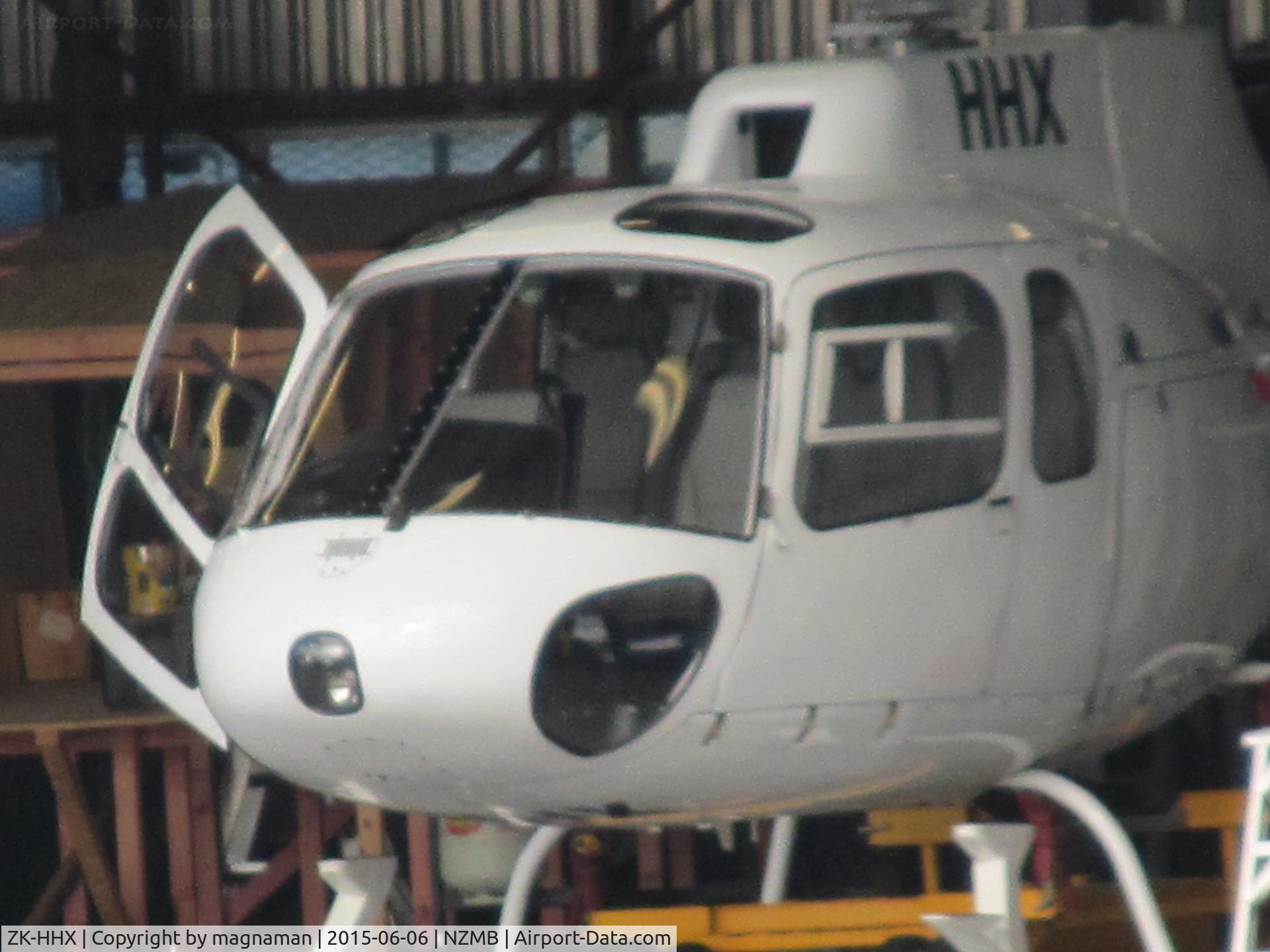 ZK-HHX, 1986 Aerospatiale AS-350B-2 Ecureuil C/N 1940, Hiding in mechanics bay hangar - long shot from harbour edge