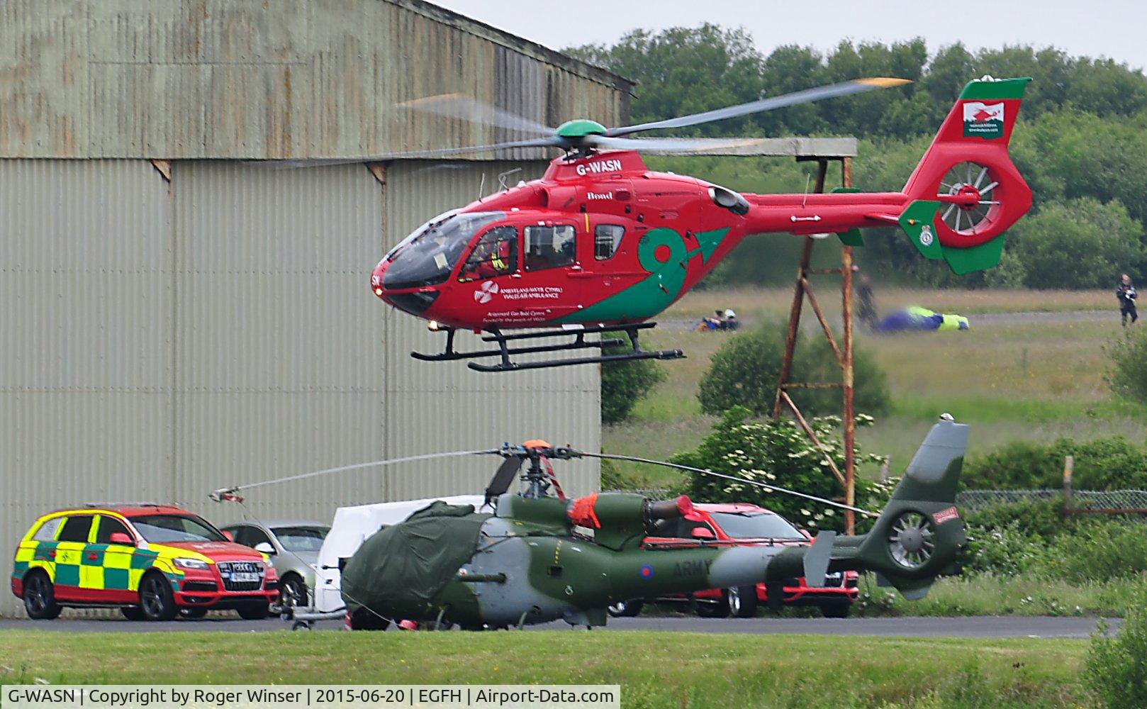G-WASN, 2008 Eurocopter EC-135T-2+ C/N 0746, Wales Air Ambulance helicopter (Helimed 57) departing base. Parked up is Army Air Corps Westland Gazelle AH.1 helicopter ZB665.