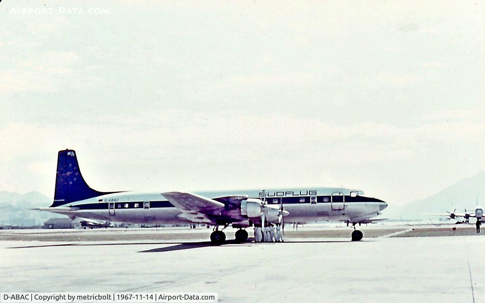 D-ABAC, 1957 Douglas DC-7C Seven Seas Seven Seas C/N 45187, HKG Kai Tak. Everyone under the airplane to escape heat.Yes,even in November.