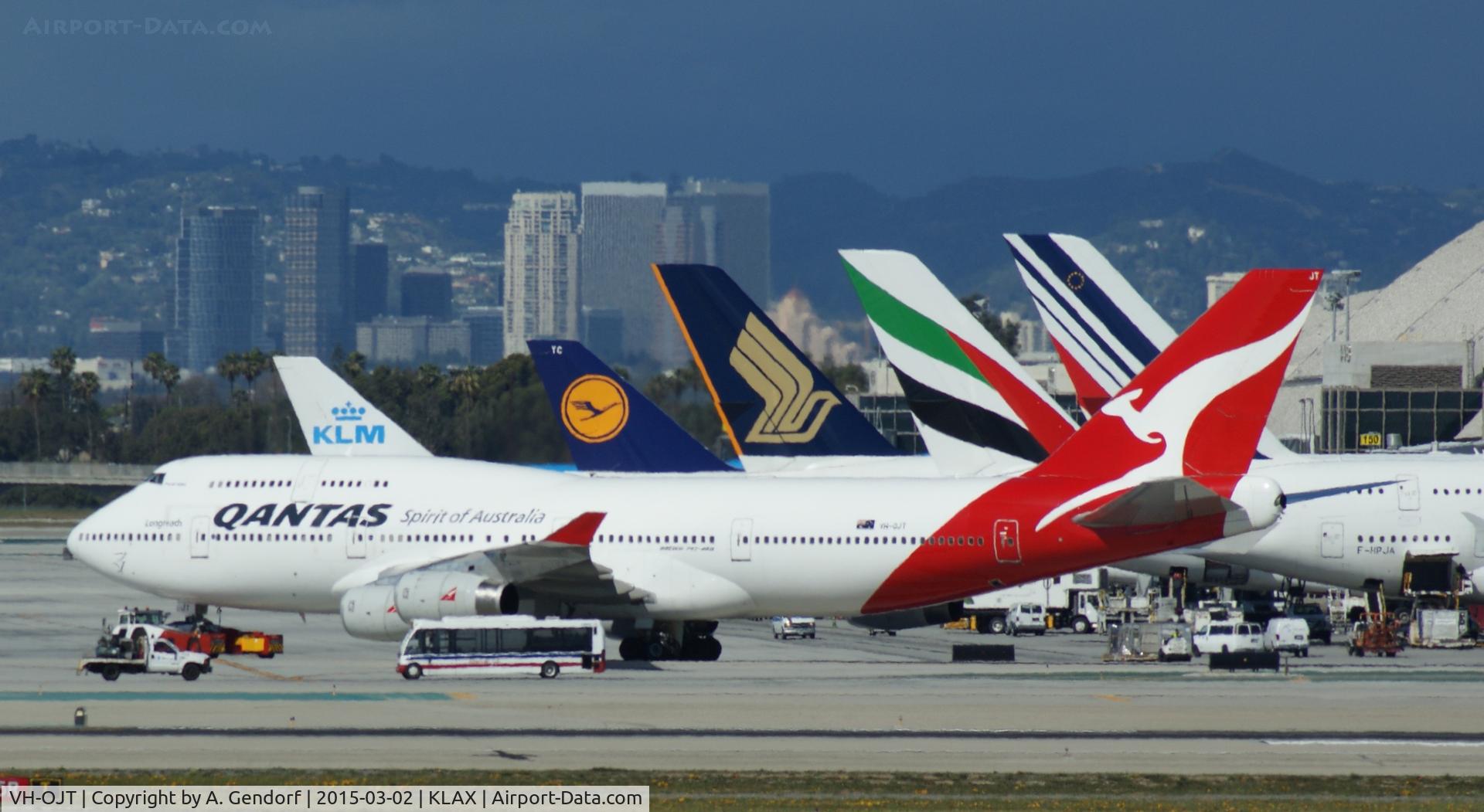 VH-OJT, 1999 Boeing 747-438 C/N 25565, Qantas, is here towed alongside all the other heavy jets, waiting at the Tom Bradley Terminal at Los Angeles Int'l(KLAX)