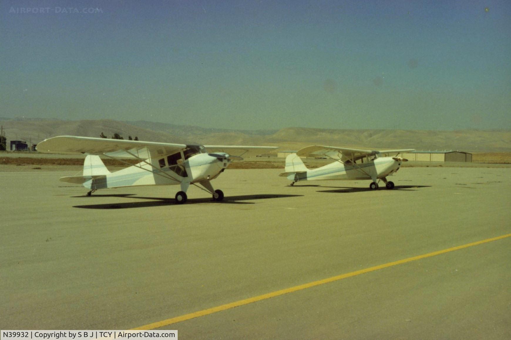 N39932, 1945 Taylorcraft BC12-D C/N 6585, 932 with N9078E at Tracy airport. Two very good planes.With the same Cont.65,one is 10-12 MPH faster yet landing & takeoff are  about the same. View is to the west.