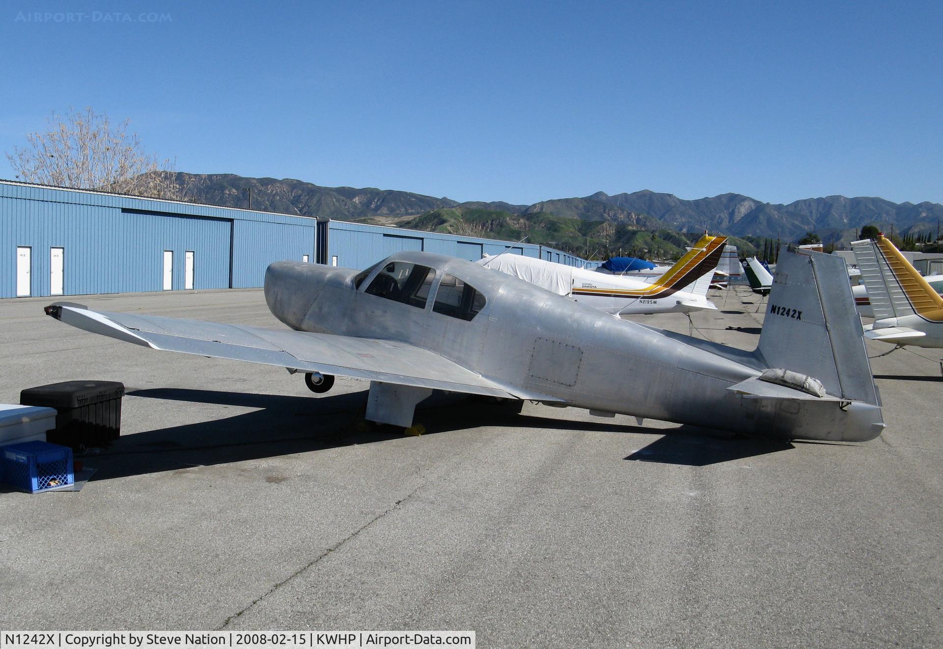N1242X, 1963 Mooney M20E C/N 115, 1963 Mooney M20E stripped of paint, minus prop and engine and resting on its tail @ Whiteman Airport, Pacoima, CA  @ Whiteman Airport, Pacoima, CA