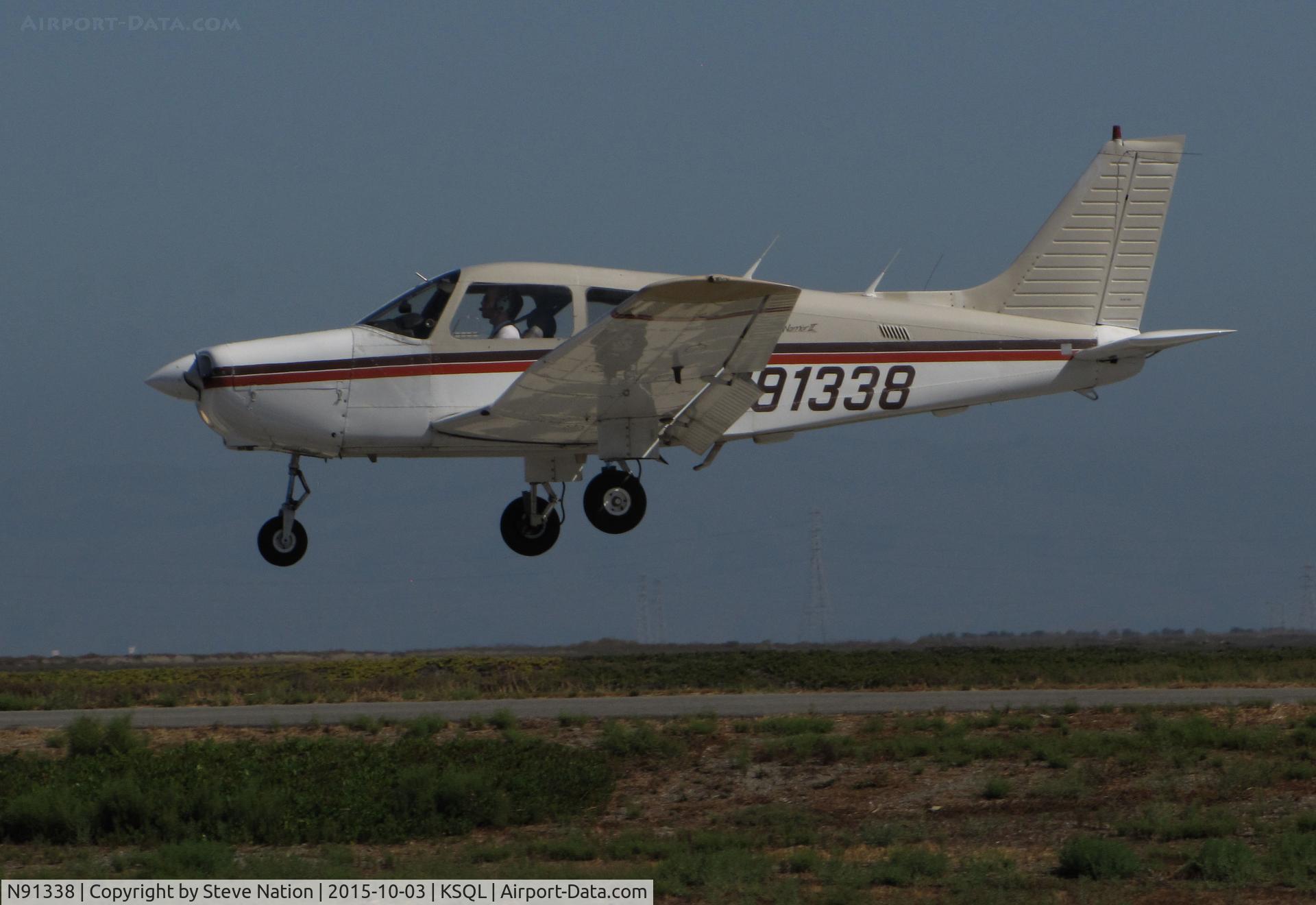 N91338, 1985 Piper PA-28-161 C/N 28-8616008, Locally-based 1985 Piper PA-28-161 Cherokee over the threshold @ San Carlos Airport, CA