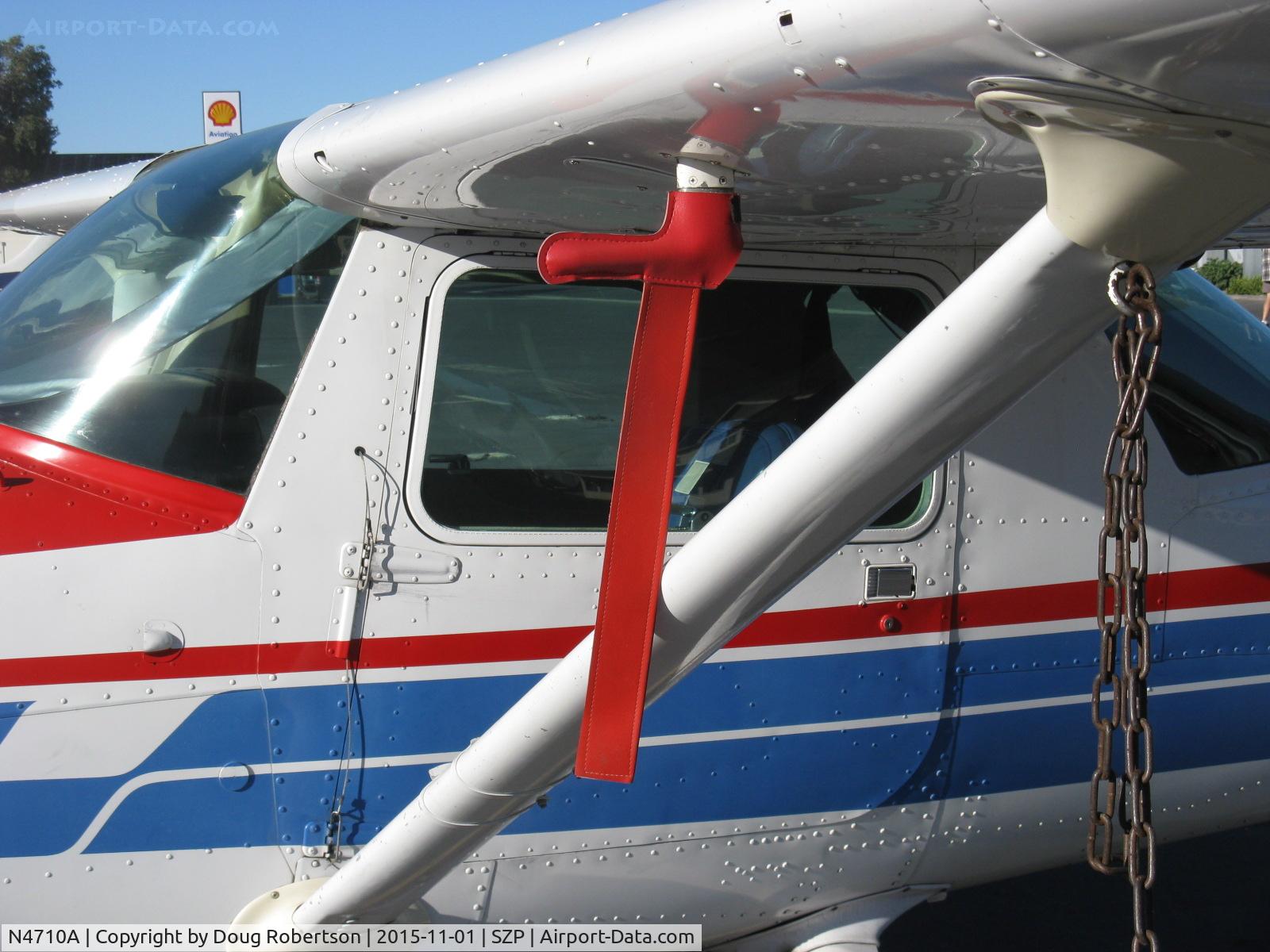 N4710A, 1979 Cessna A152 Aerobat C/N A1520876, 1979 Cessna A152 AEROBAT, Lycoming O-235 115 Hp, closeup of pitot tube cover with pre-flight check bannner & quick-release pilot-door hardware, other door same for bailout-don't forget your parachute!