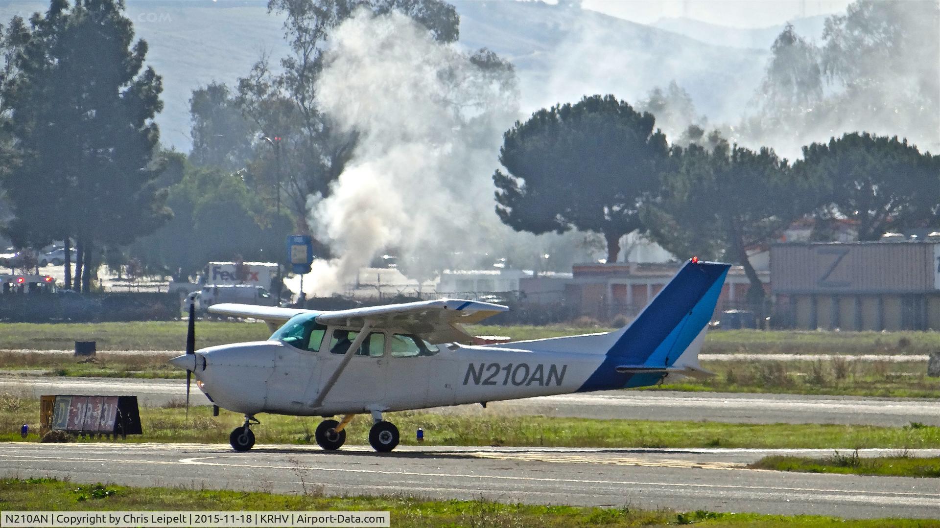 N210AN, 1975 Cessna 172M C/N 17264678, Locally-based 1975 Cessna 172M clear of runway 31R at Reid Hillview Airport, San Jose, CA. Don't ask me what's going on in the background.