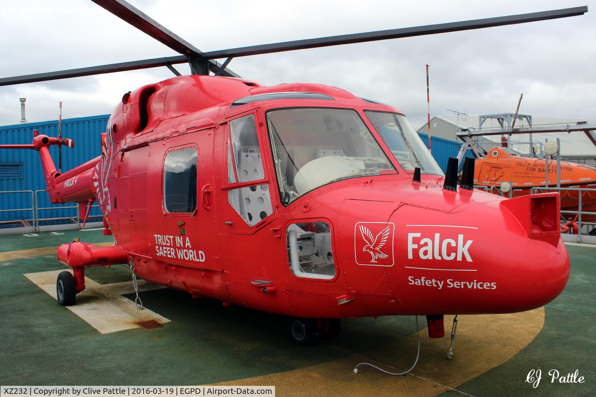 XZ232, 1977 Westland Lynx HAS.3GMS C/N 009, In use as a training aid at the Falck Safety Services premises at Dyce, Aberdeen, over the north-east fence from Aberdeen airport EGPD. Mounted on a mock helipad for students of the oil industry. Last served with RN 702 NAS coded 632