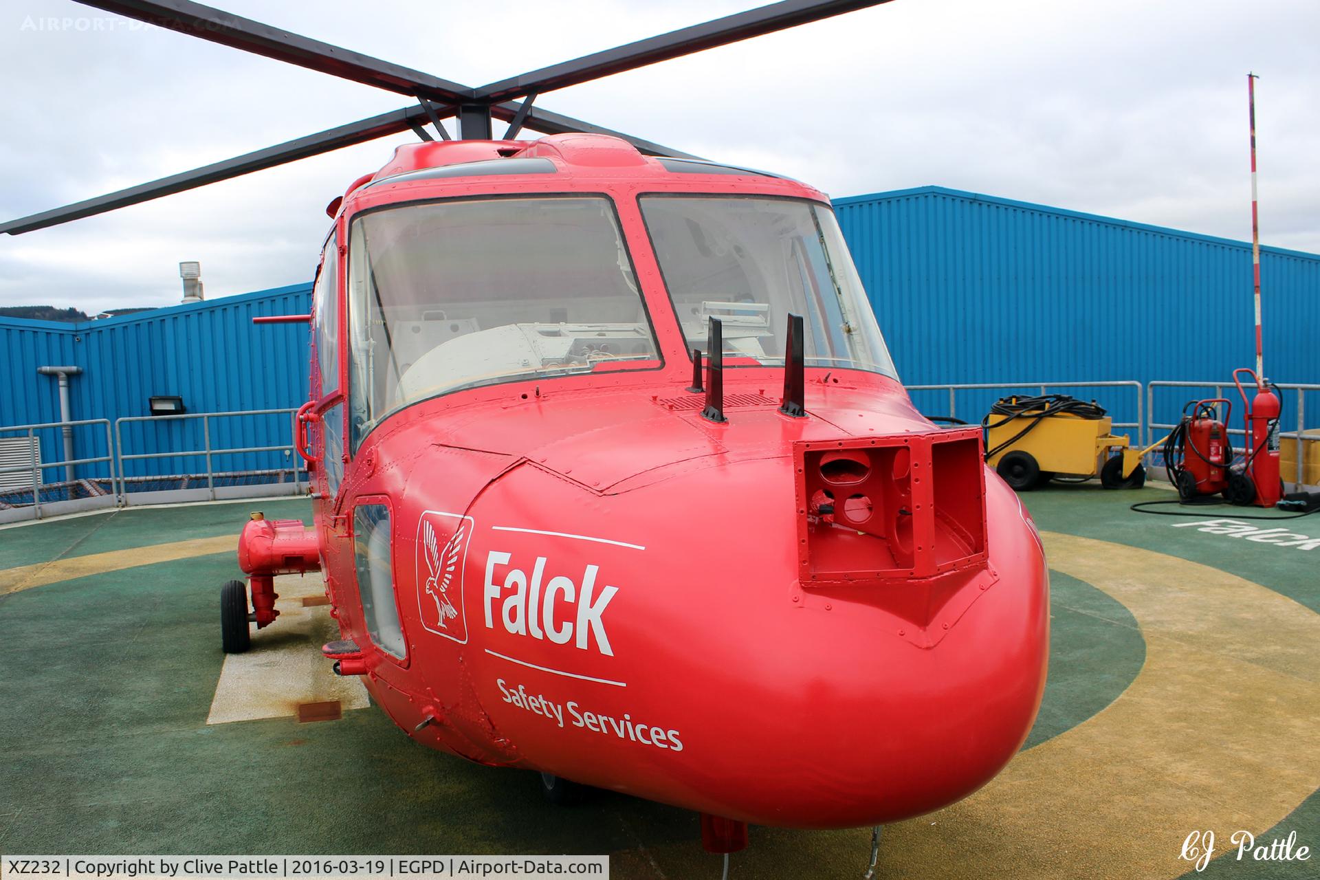 XZ232, 1977 Westland Lynx HAS.3GMS C/N 009, In use as a training aid at the Falck Safety Services premises at Dyce, Aberdeen, over the north-east fence from Aberdeen airport EGPD. Mounted on a mock helipad for students of the oil industry. Last served with RN 702 NAS coded 632