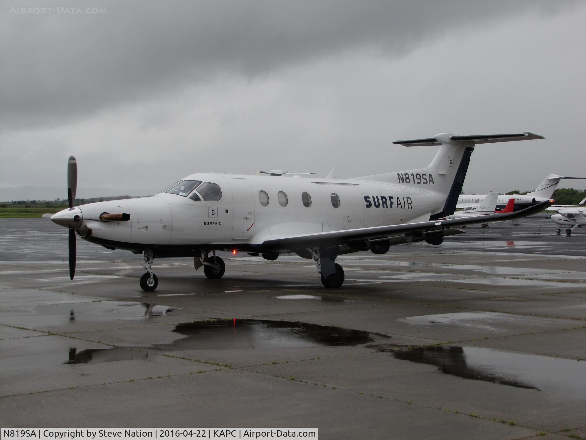 N819SA, 2014 Pilatus PC-12/47E C/N 1512, SURF AIR 2014 Pilatus PC-12/47E with airstair closed waiting on GA ramp @ rainy Napa County Airport, CA for return flight to KHHR