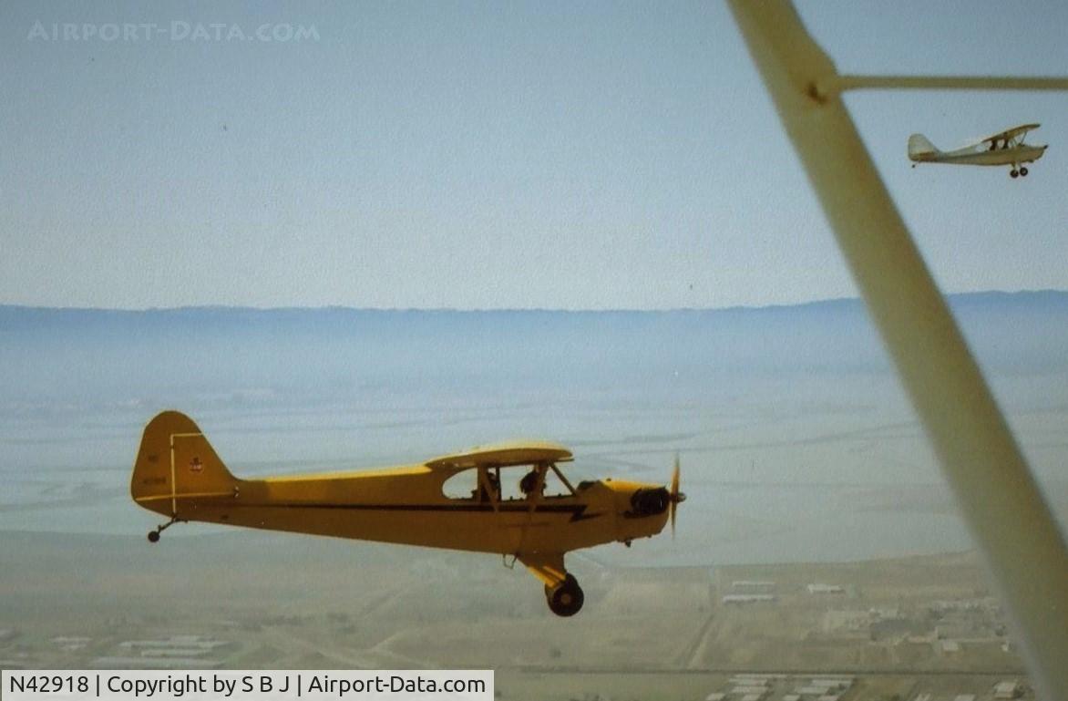 N42918, 1945 Piper J3C-65 Cub C/N 15254, Cub 918 with Champ 25E top right flying in the S F Bay Area. View is to the west with Moffett Field (NUQ) seen in the distance above the tail of 918..