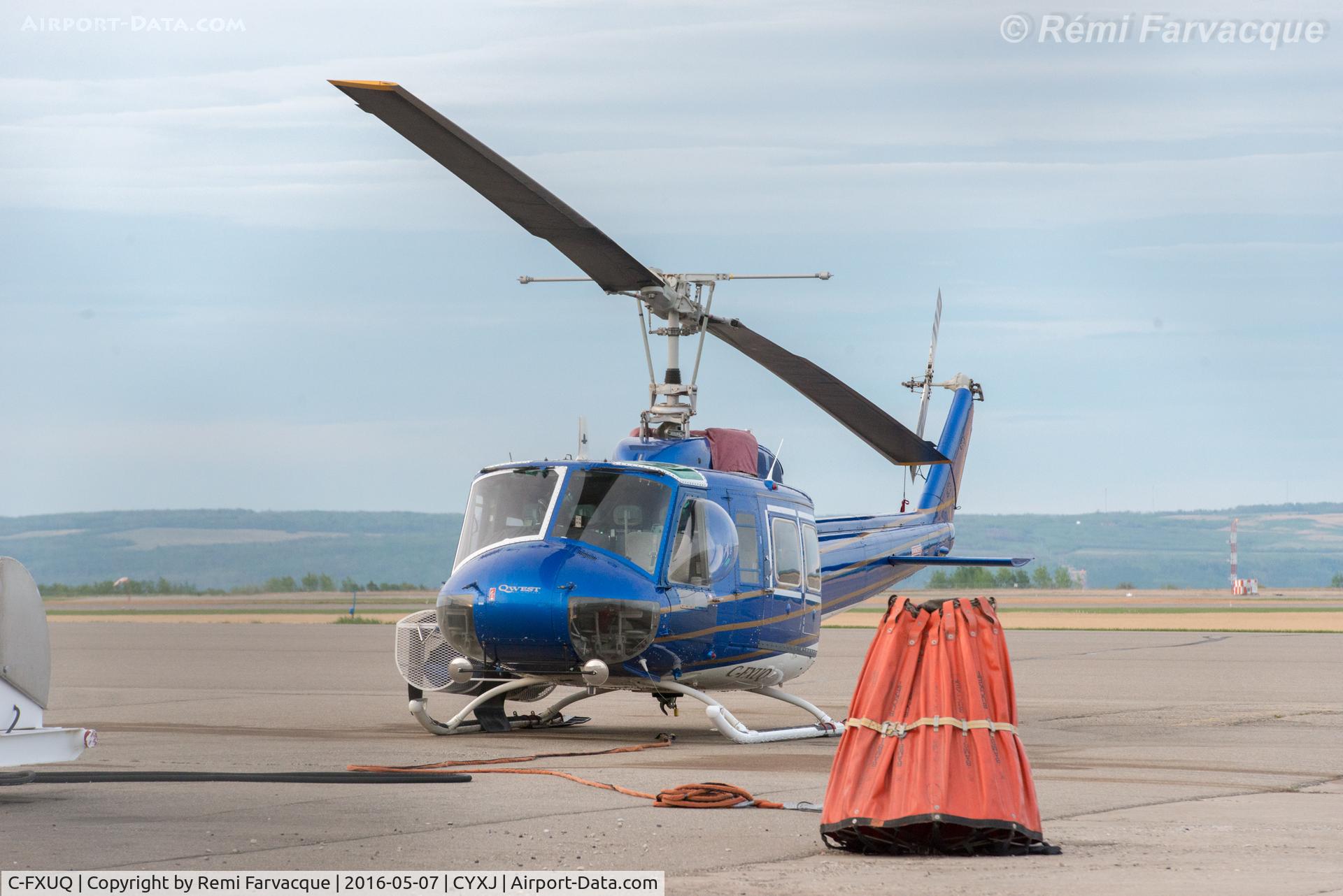 C-FXUQ, 1975 Bell 205A-1 C/N 30176, Parked by control tower. Fighting forest fires during the day. With sling bucket.