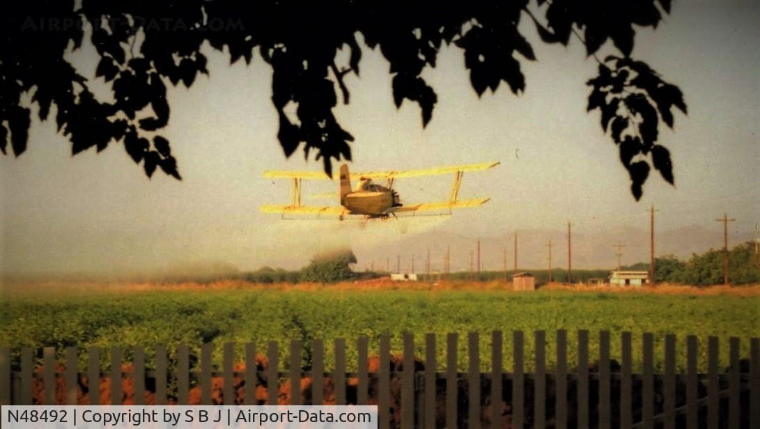 N48492, 1976 Grumman-Schweizer G-164B C/N 47B, View of 492 spraying tomatos on my property that I leased out. Tight fit as the distance from the near fence to the far shed (pump house) is only 1500 feet. This pilot did a very good job. Sure he had no idea he was being graded.