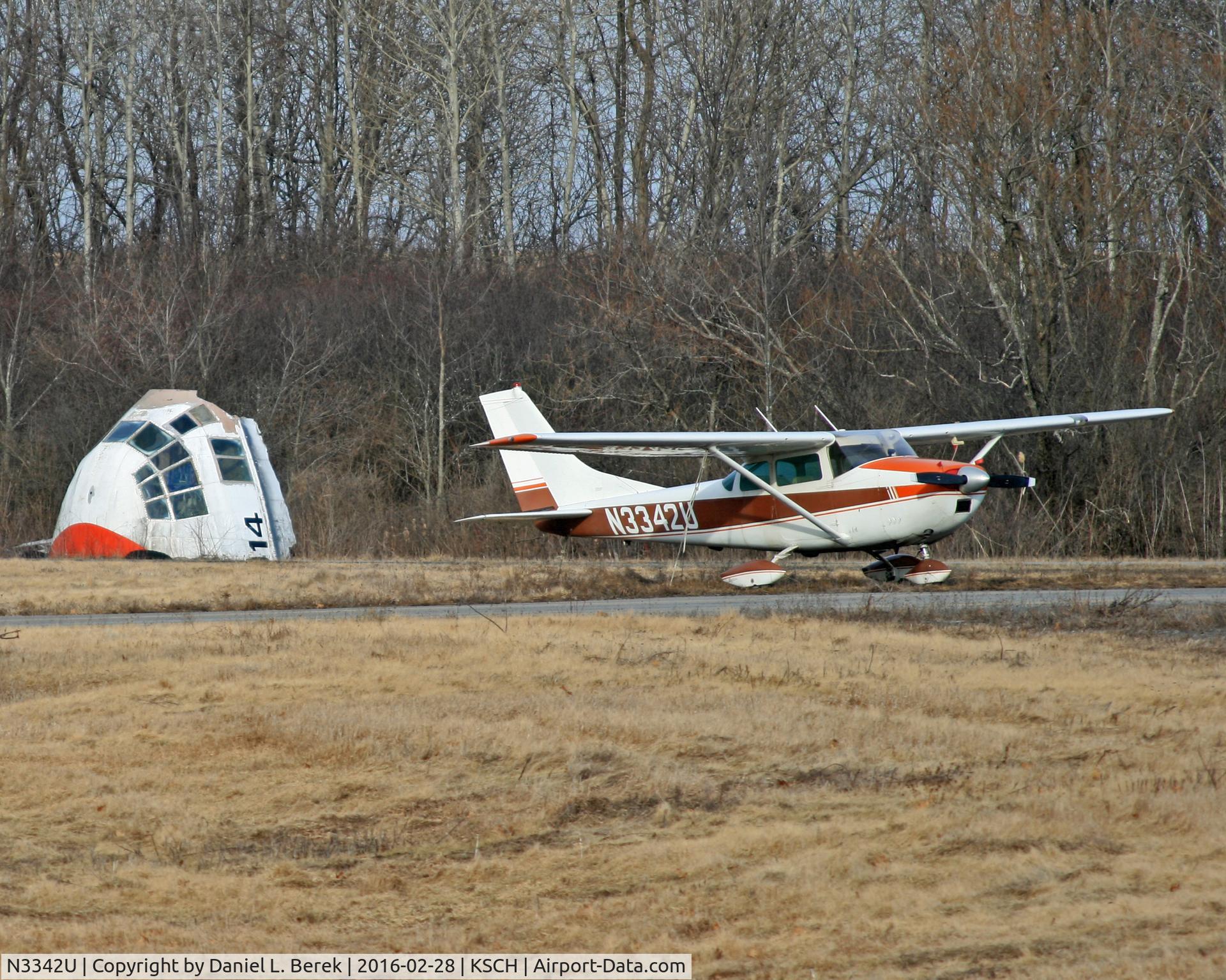 N3342U, 1963 Cessna 182F Skylane C/N 18254742, A 1963 Skylane stands guard over the front fuselage of C-130E 66-4399.