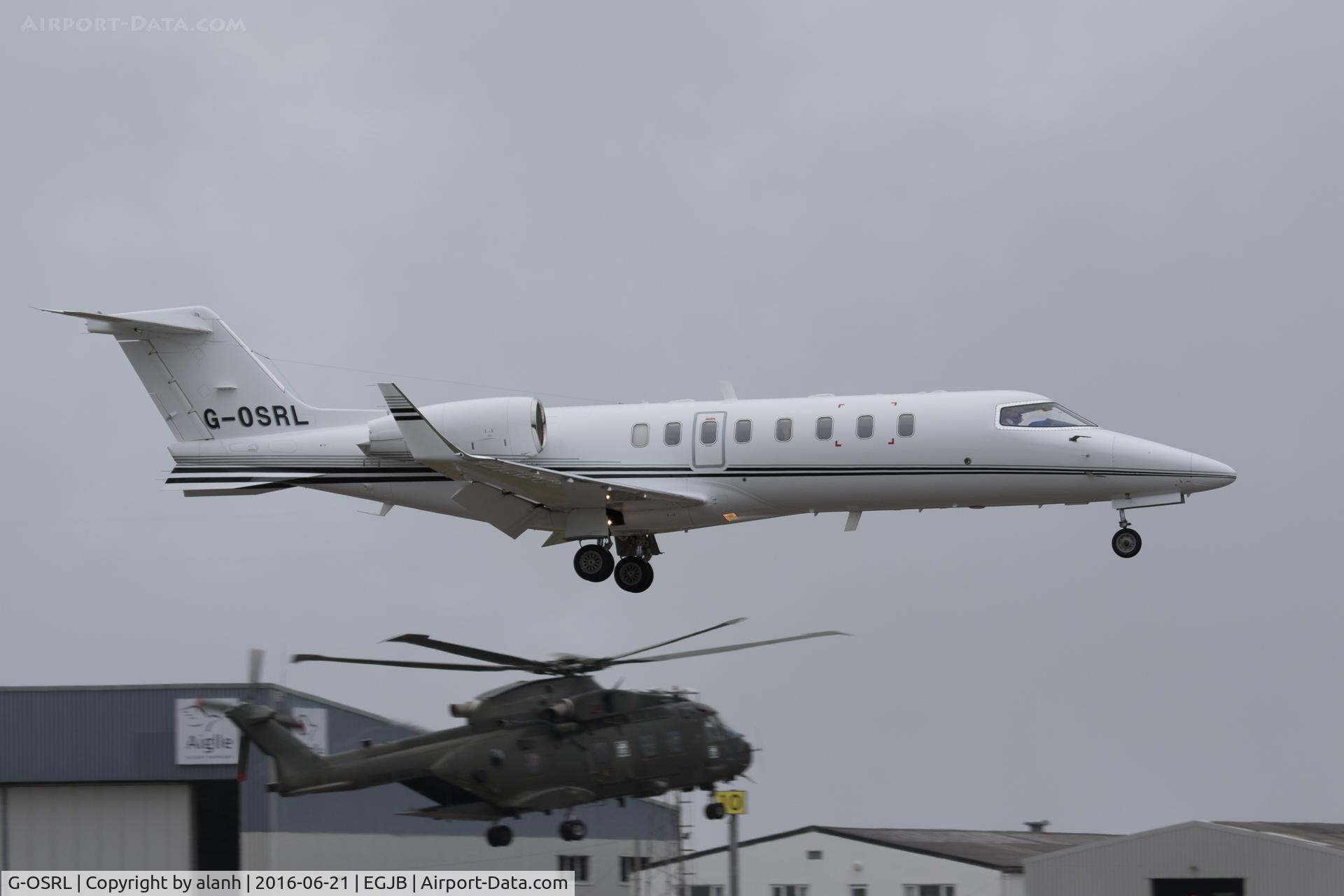 G-OSRL, 2009 Learjet 45 C/N 45-391, Finals for 27; Royal Navy Merlin ZJ135 conducting a hover test at the hold in the background