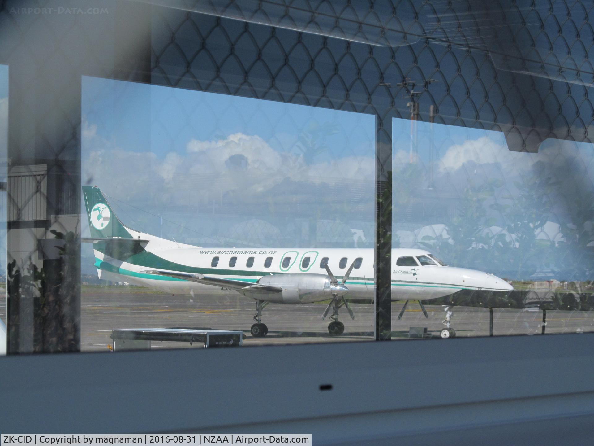 ZK-CID, 1988 Fairchild SA-227AC Metro III C/N AC-692B, Taken through wire fence then through window of passenger tunnel at domestic apron! This a/c is ex ZK-NSS
