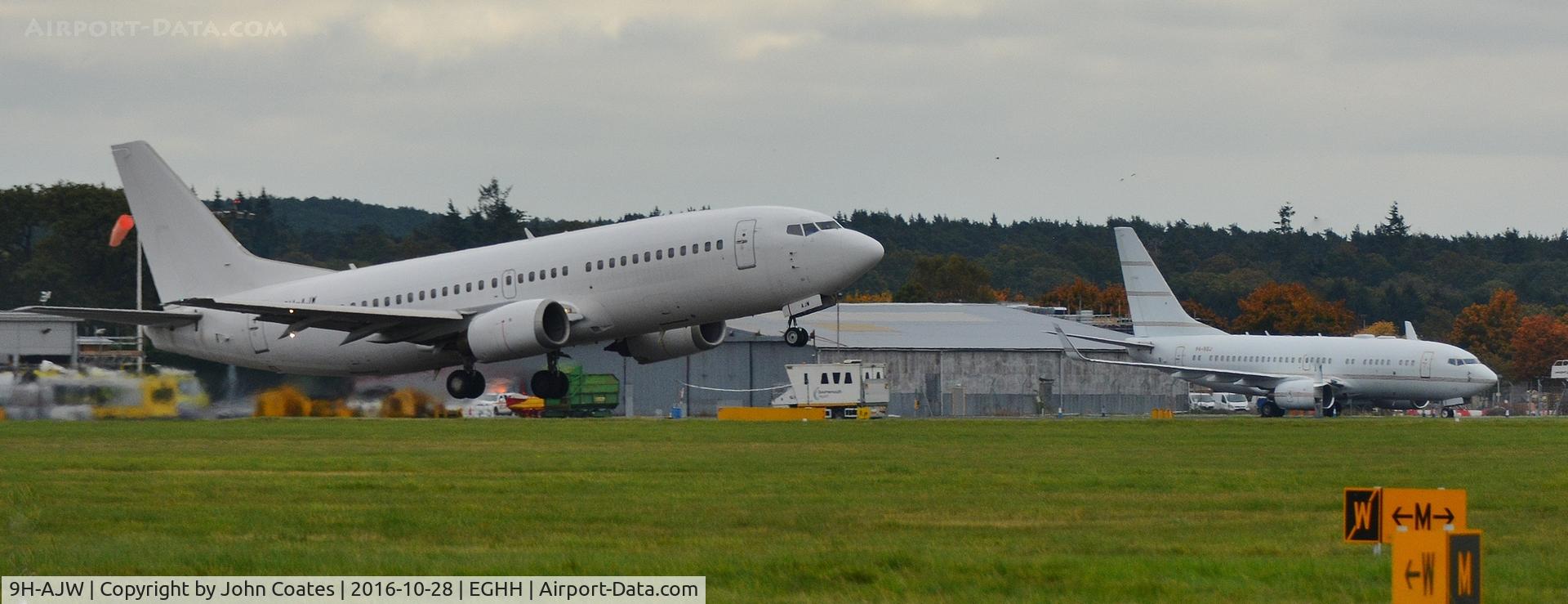 9H-AJW, 1998 Boeing 737-3U3 C/N 28733, Departing to Lasham past P4-BBJ
