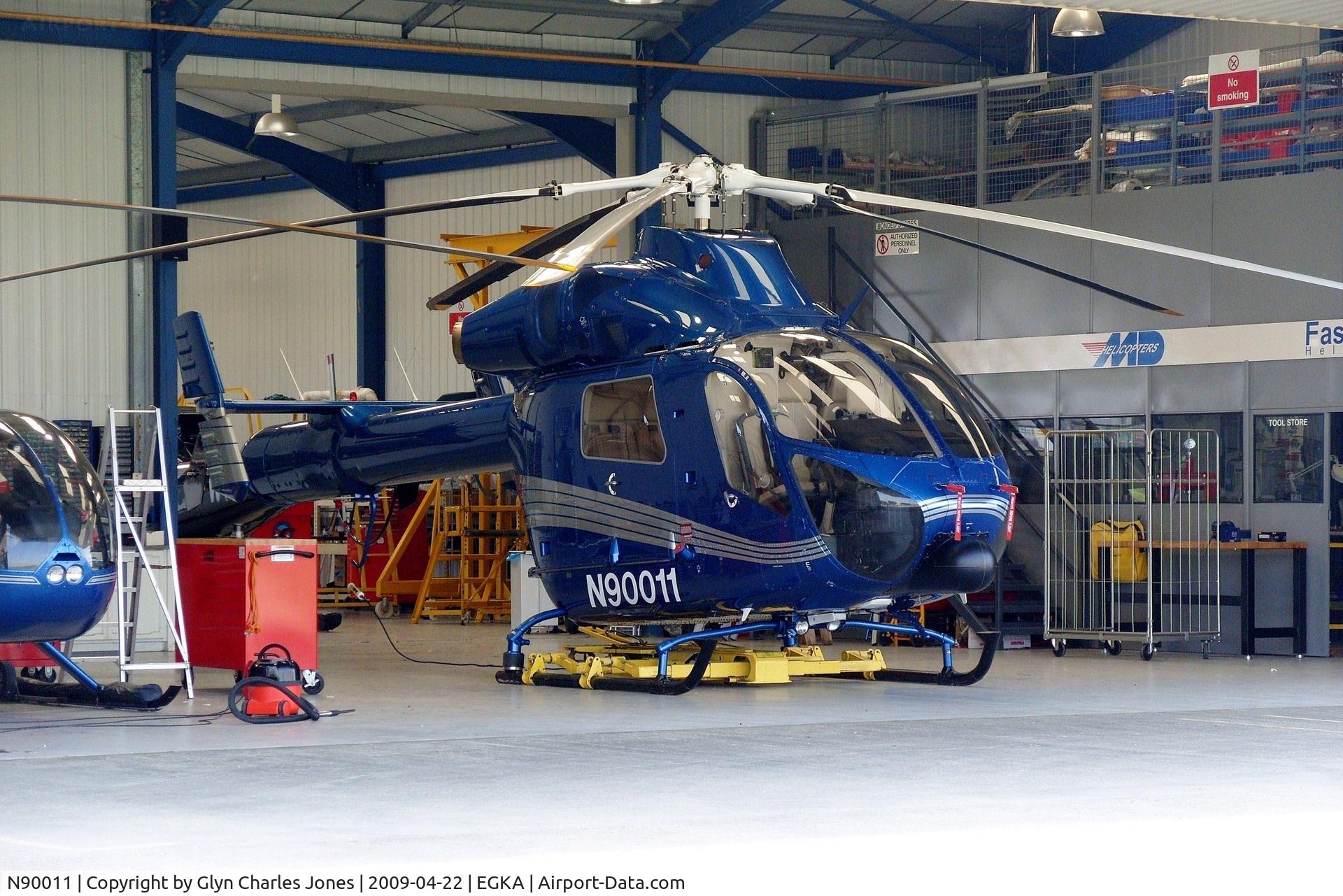 N90011, 2006 MD Helicopters MD-900 Explorer C/N 900-00115, Photo taken from the perimeter road looking into the main Fast Air hangar. Owned by Latium Helicopter Charters UK Inc Trustee.
