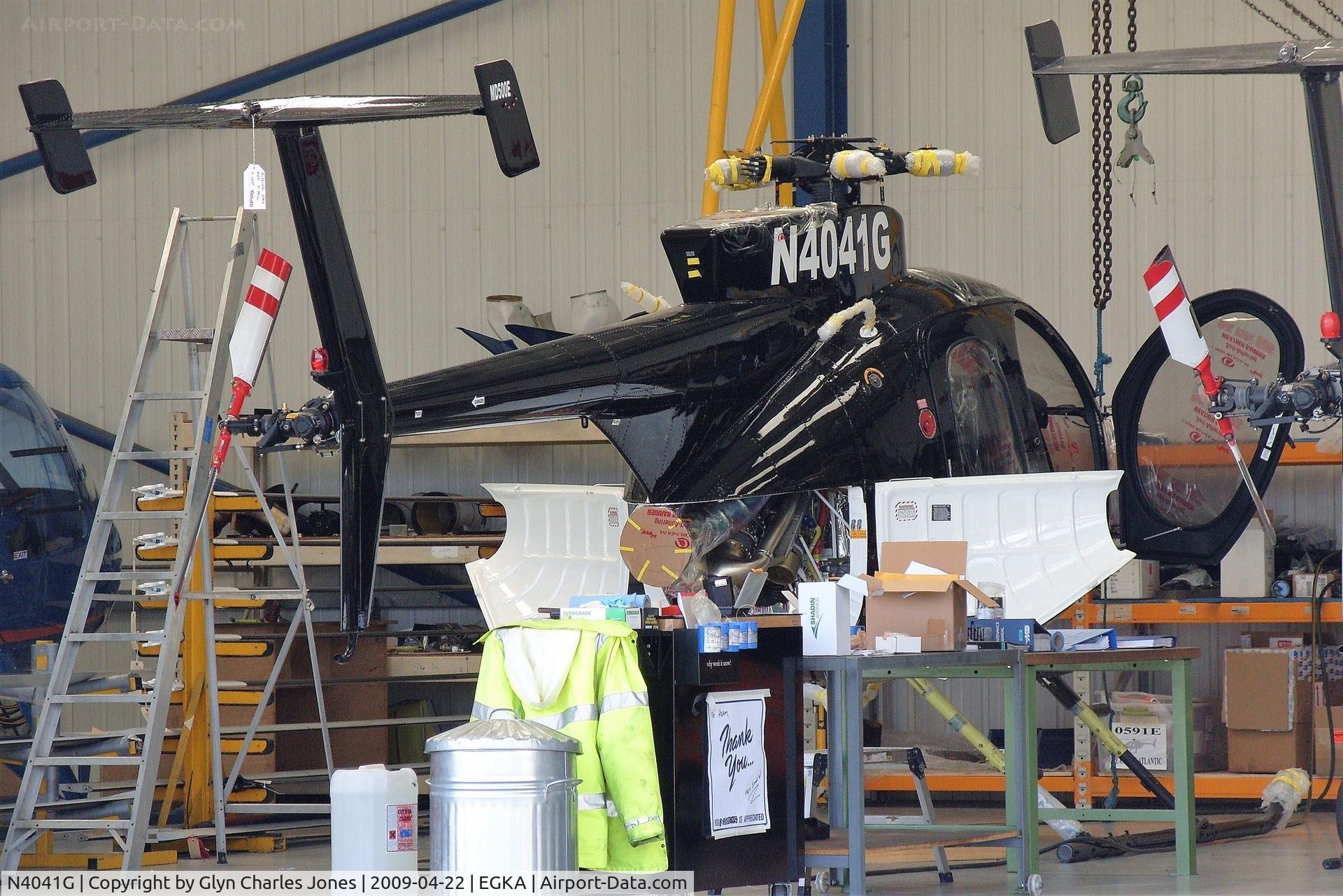 N4041G, 2009 MD Helicopters 369E C/N 0591E, Photo taken from the perimeter road looking into the smaller Fast Air hangar. Being re-assembled after being crated in from the USA. Some parts have still got the labels on! Became G-DUTY on 13 May 2009. Owned by MD Helicopters Inc.