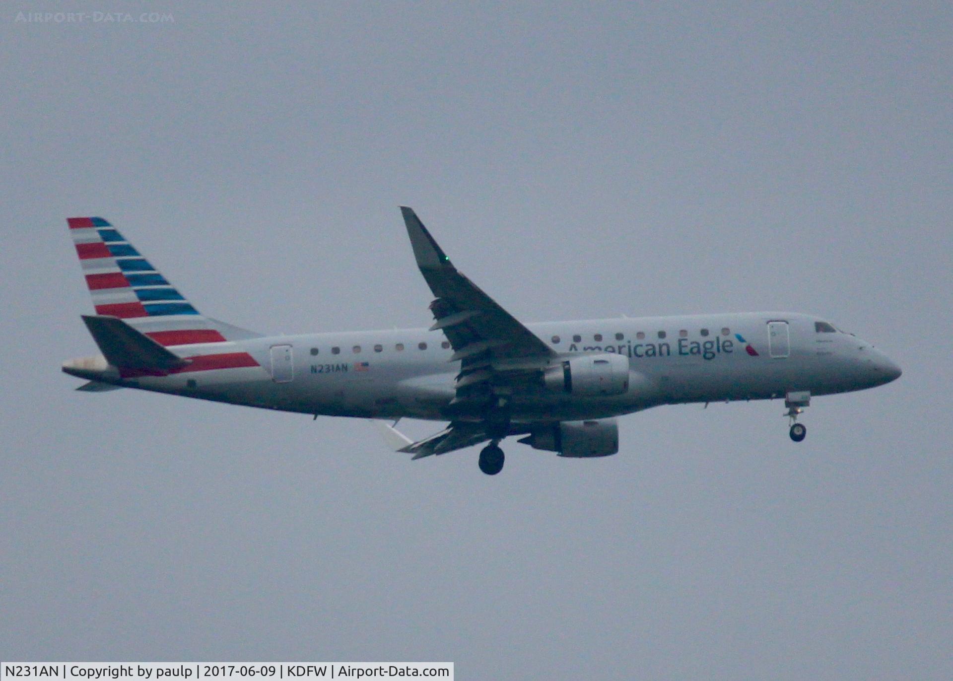 N231AN, 2016 Embraer 175LR (ERJ-170-200LR) C/N 17000554, At DFW. After a 45 minute hold because of severe storms, starting to land in heavy rain.
