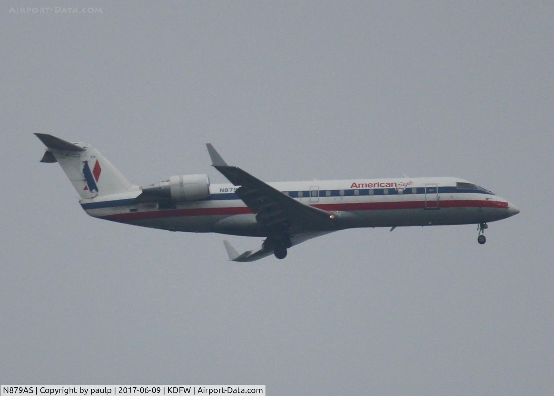 N879AS, 2002 Bombardier CRJ-200ER (CL-600-2B19) C/N 7600, At DFW. After a 45 minute hold because of severe storms, starting to land in heavy rain.