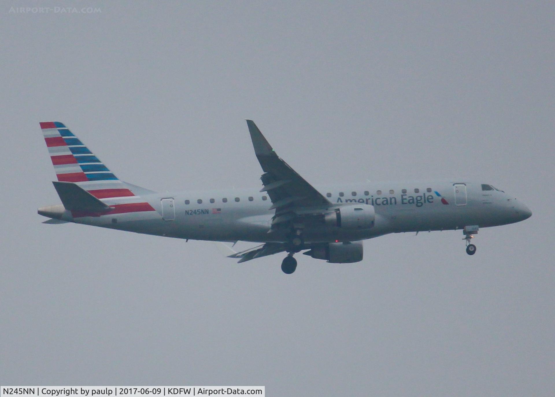 N245NN, 2016 Embraer 175LR (ERJ-170-200LR) C/N 17000614, At DFW. After a 45 minute hold because of severe storms, starting to land in heavy rain.
