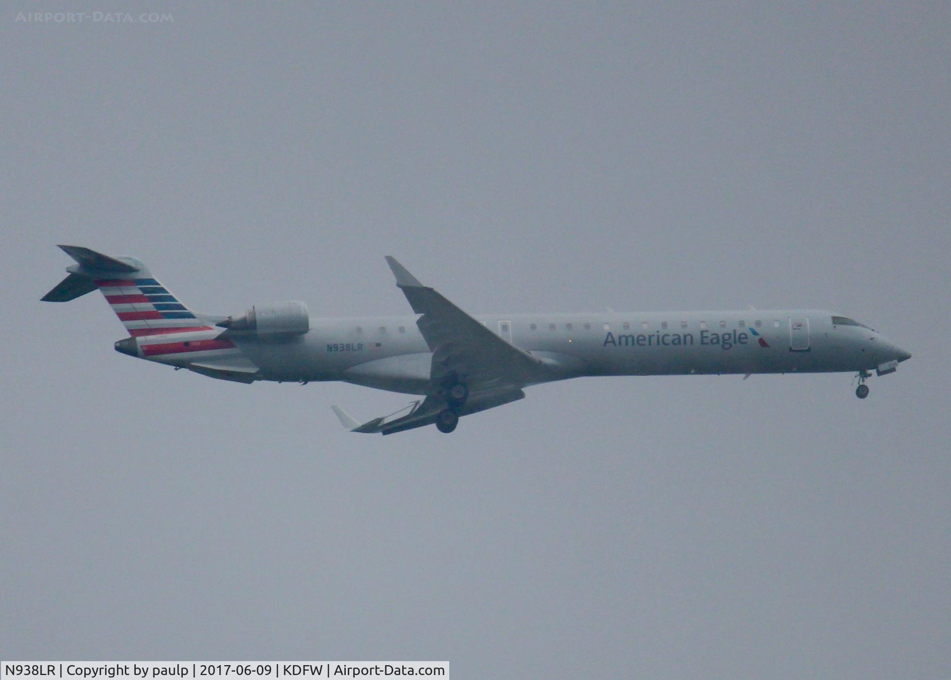 N938LR, 2005 Bombardier CRJ-900ER (CL-600-2D24) C/N 15038, At DFW. After a 45 minute hold because of severe storms, starting to land in heavy rain.
