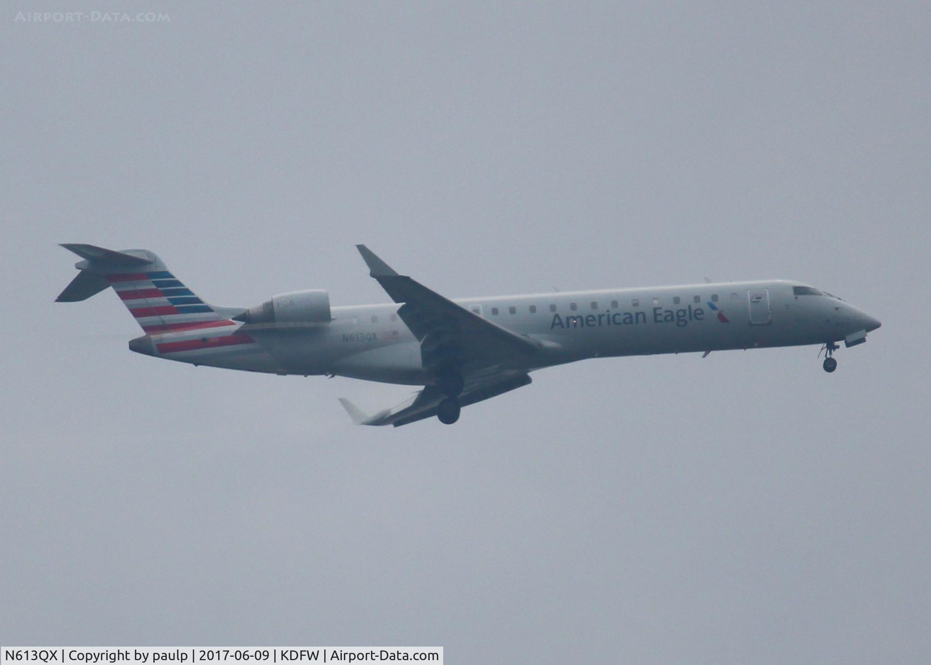 N613QX, 2002 Bombardier CRJ-701 (CL-600-2C10) Regional Jet C/N 10045, At DFW. After a 45 minute hold because of severe storms, starting to land in heavy rain.