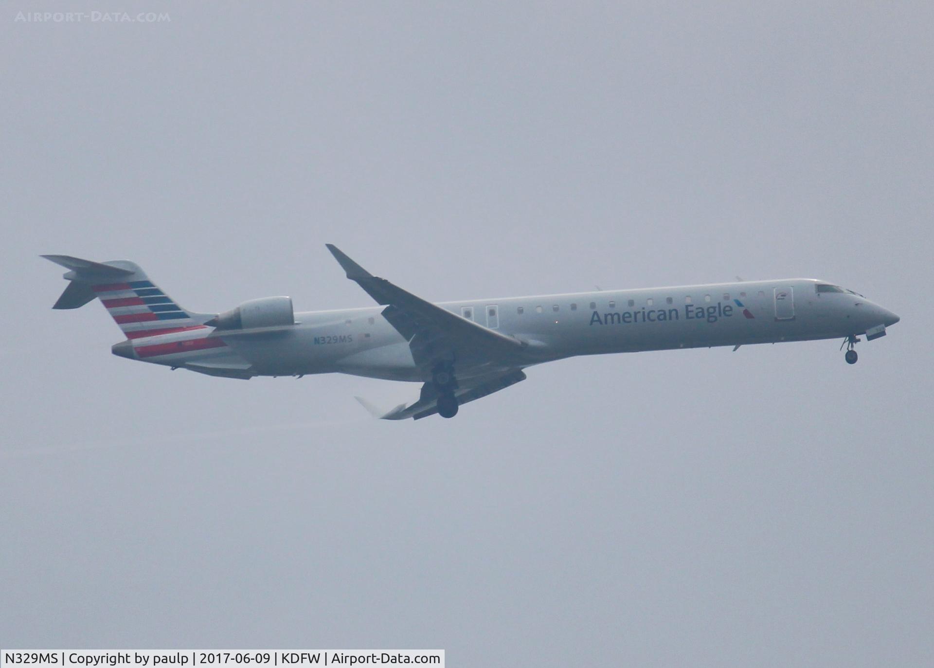 N329MS, 2008 Bombardier CRJ-900ER NG (CL-600-2D24) C/N 15126, At DFW. After a 45 minute hold because of severe storms, starting to land in heavy rain.