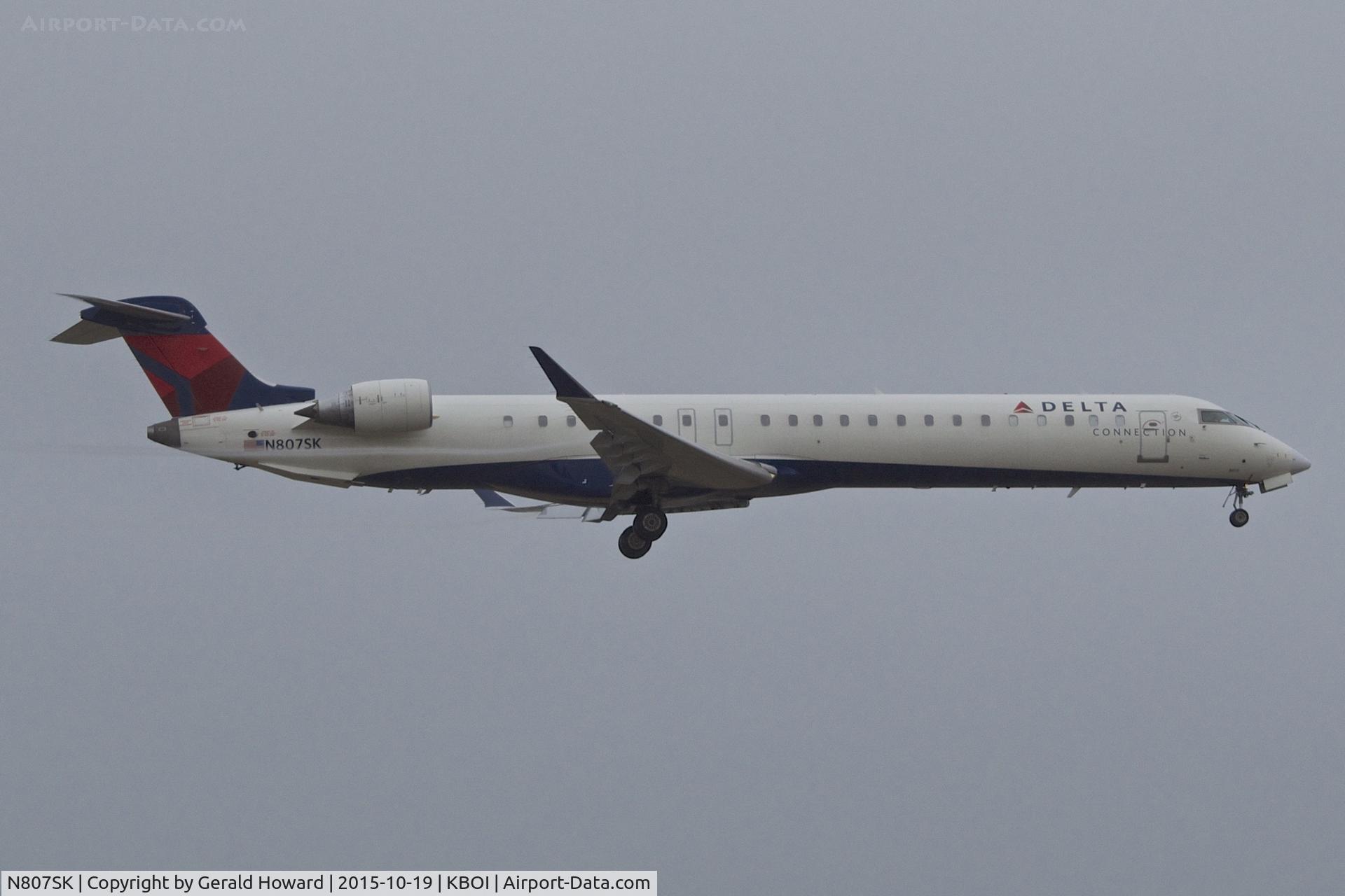 N807SK, 2006 Bombardier CRJ-900ER (CL-600-2D24) C/N 15082, Landing RWY 10L. Vortex just becoming visible off flaps.