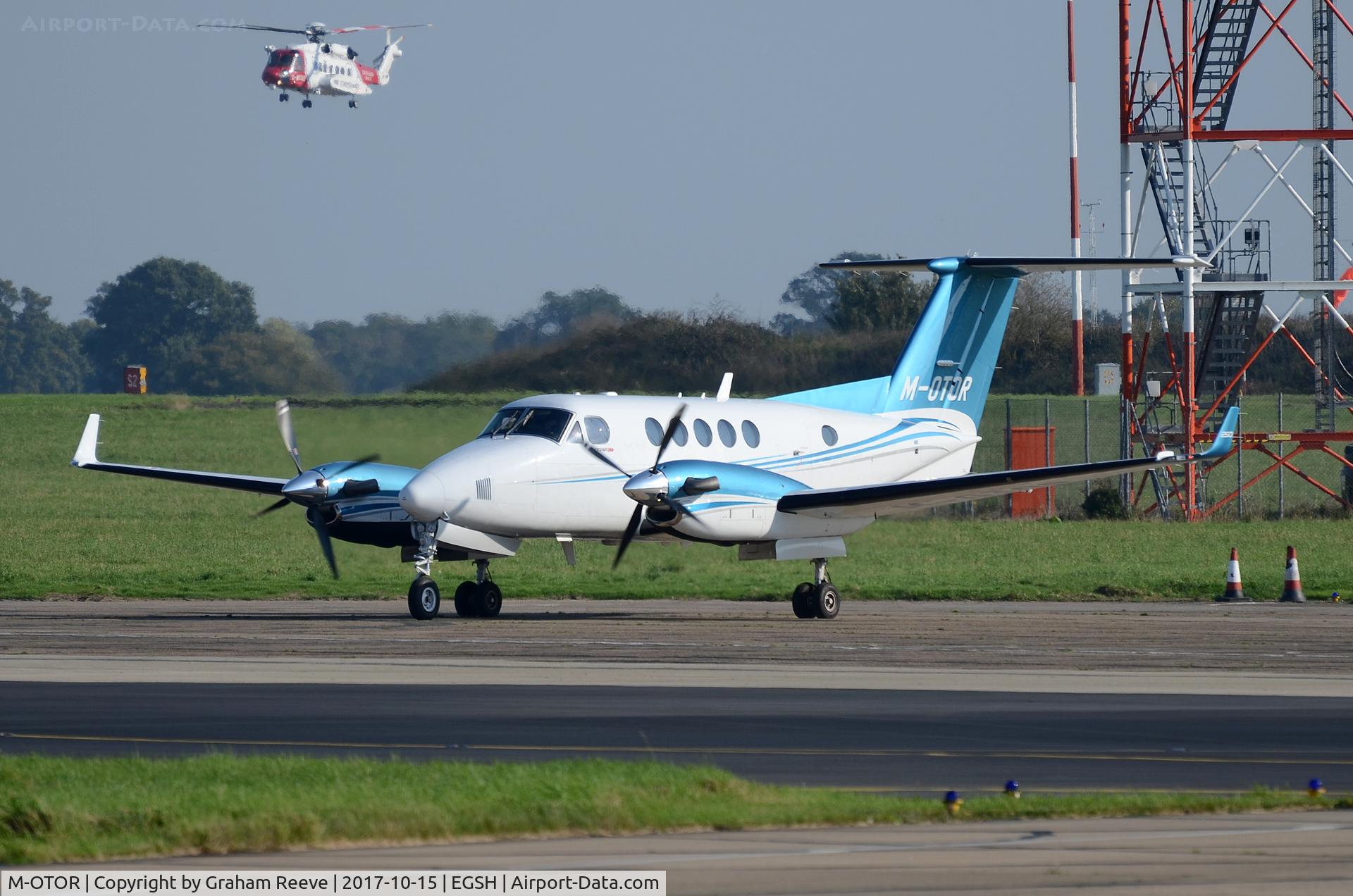 M-OTOR, 2014 Hawker Beechcraft B200GT King Air King Air C/N BY-200, Parked at Norwich with G-MCGE landing in the back ground.