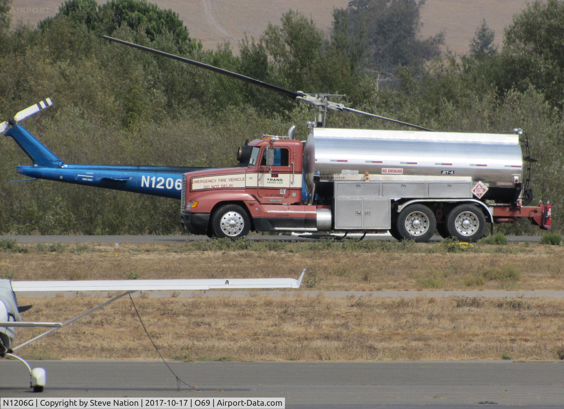 N1206G, 1966 Bell UH-1H Iroquois C/N 5269 (66-0786), DON'T THINK THIS THING WILL FLY! Trans Aero (Cheyenne, WY) 1966 Bell UH-1H taking a break behind the fuel truck at Petaluma Municipal Airport, CA temporary home base while making water drops on the devastating October 2017 Northern California wildfires