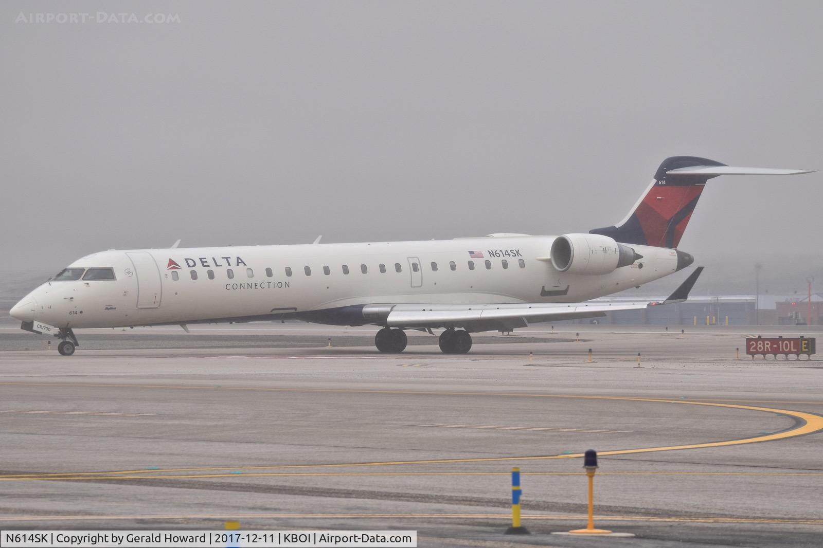 N614SK, 2002 Bombardier CRJ-701 (CL-600-2C10) Regional Jet C/N 10051, Turning onto Echo from RWY 28R as snow begins to fall.
