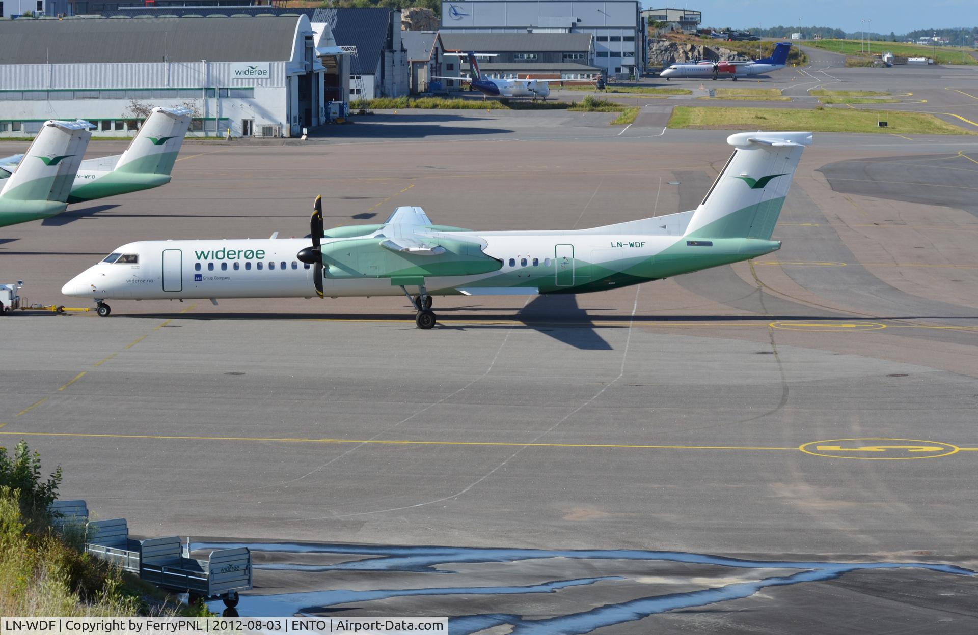 LN-WDF, 2009 De Havilland Canada DHC-8-402Q Dash 8 C/N 4244, Dash 8 towed to stand at domestic terminal to the left with hangars further down and at the top you can see some museum aircraft. Runway is to the right. Nice view from long term car park over the whole field.