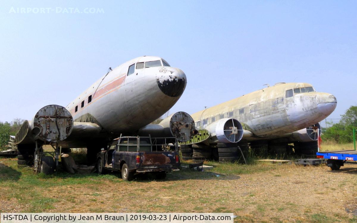 HS-TDA, 1943 Douglas DC-3 C/N 13726, ex 42-93777 / cn 13726 ex HS-TDA Thai Airways dismantled in a lumber yard on countryroad #3056 in Phachi. province of Ayutthaya / Thailand. Next to her ex 44-76842 ex RAF KN559
