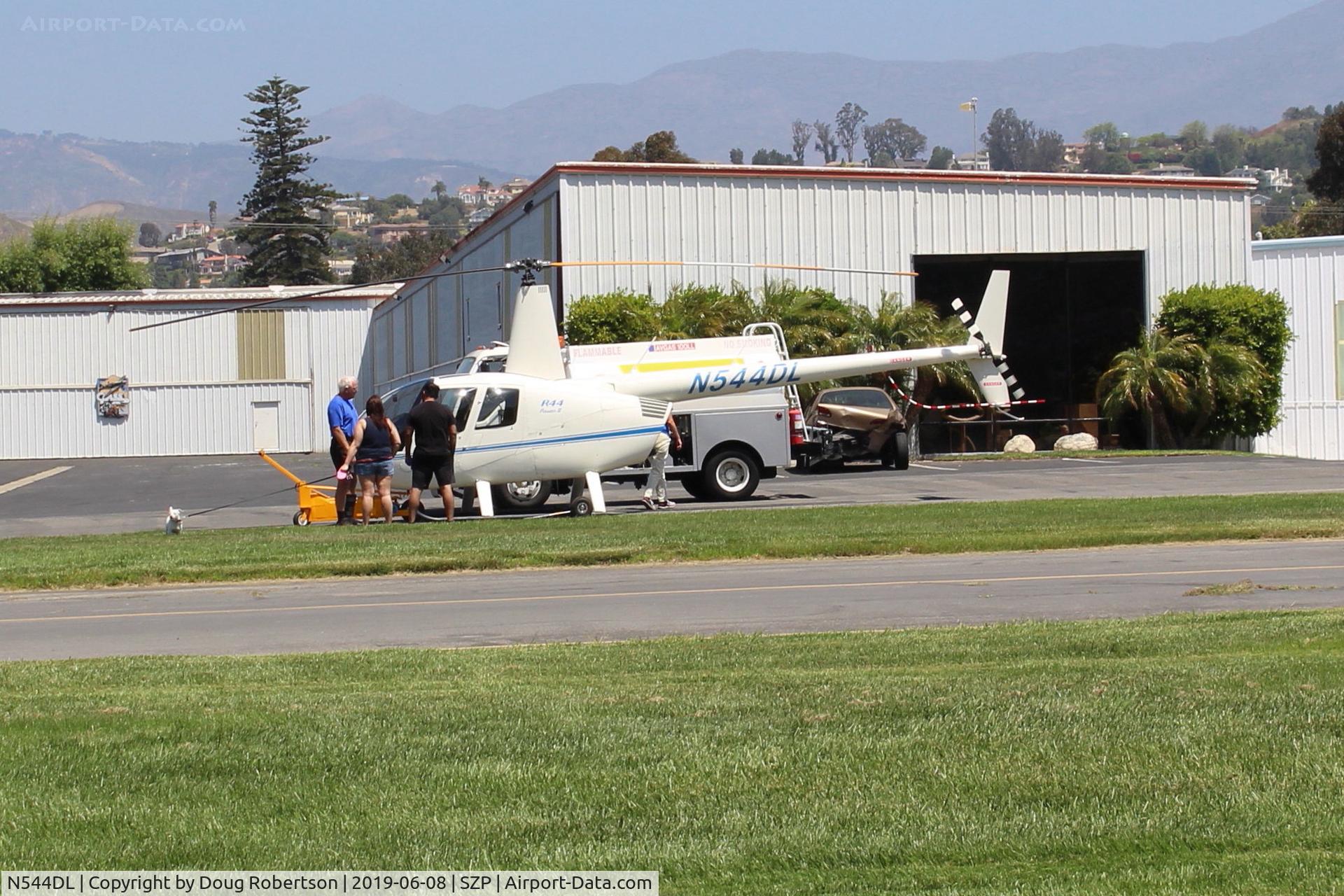 N544DL, 2005 Robinson R44 Raven II C/N 10783, 2005 Robinson R44 RAVEN II, Lycoming IO-540-AE1A5 260 Hp de-rated to 205 Hp continuous, owner chat with interested onlookers near it's hangar (just behind with large window). Refuel by truck.