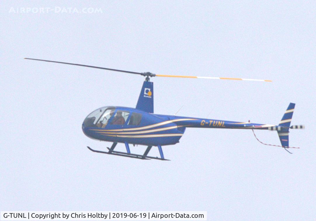 G-TUNL, 2007 Robinson R44 Raven II C/N 11628, Bearing its new registration and sporting a new livery over Potters Bar, Herts.