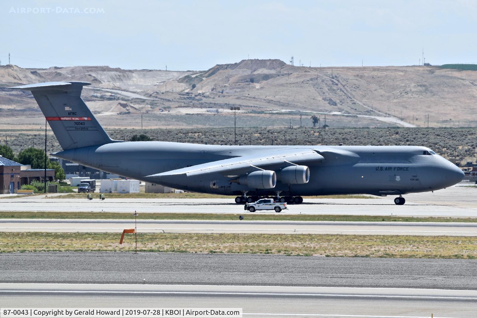 87-0043, 1988 Lockheed C-5M Super Galaxy C/N 500-129, Getting ready to taxi with follow me vehicle driving past. 439th Airlift Wing 