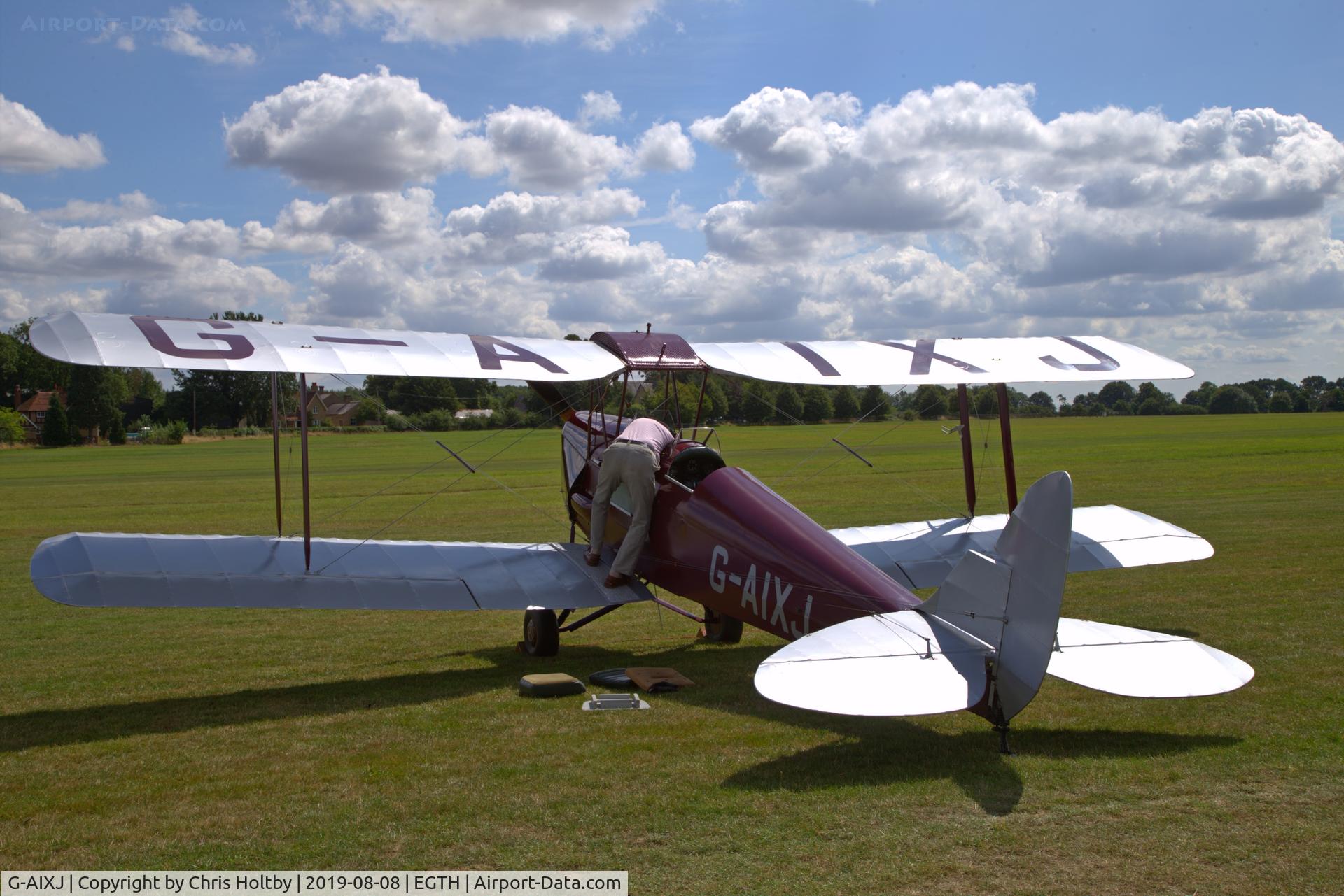 G-AIXJ, 1942 De Havilland DH-82A Tiger Moth II C/N 85434, 1942 Tiger Moth on show at the 'Gathering of Moths' 2019 at Old Warden with its owner working under the cockpit seat