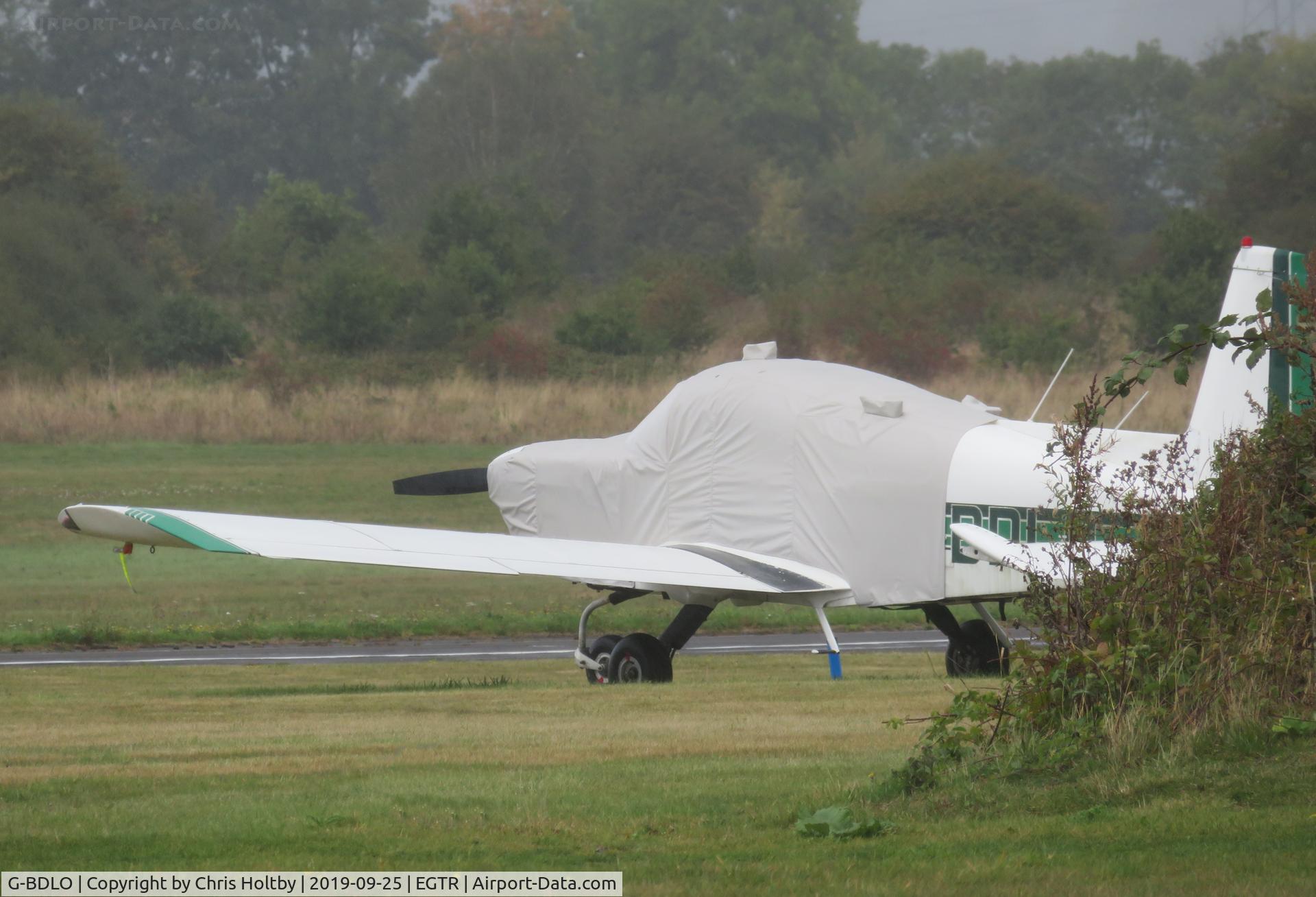 G-BDLO, 1975 Grumman American AA-5A Cheetah C/N AA5A-0026, Grumann Cheetah parked and fully covered at Elstree in the rain
