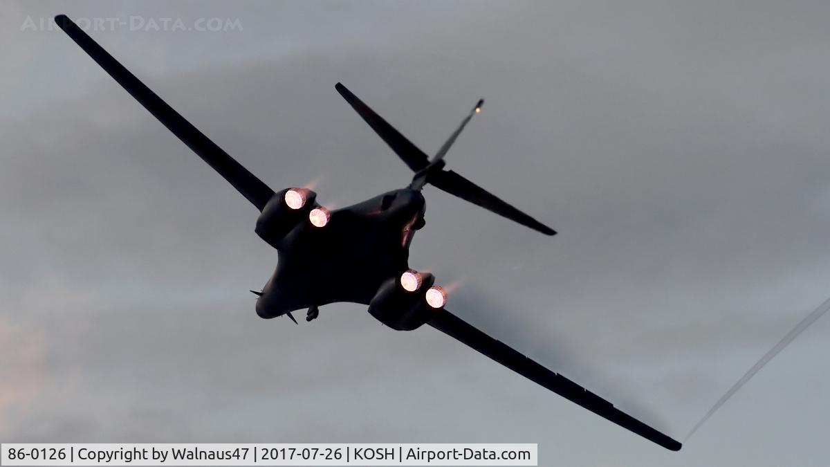 86-0126, 1986 Rockwell B-1B Lancer C/N 86, Rear view of USAF B-1B AF 86-0126 Cn 86 starting a Dusk ‘Afterburner Vapour Run’, with wings swept forward. Photo taken at the start of the Night Airshow, at Air Venture Oshkosh on 26Jul2017. A wingtip vortex is streaming from the Stbd wing while climbing