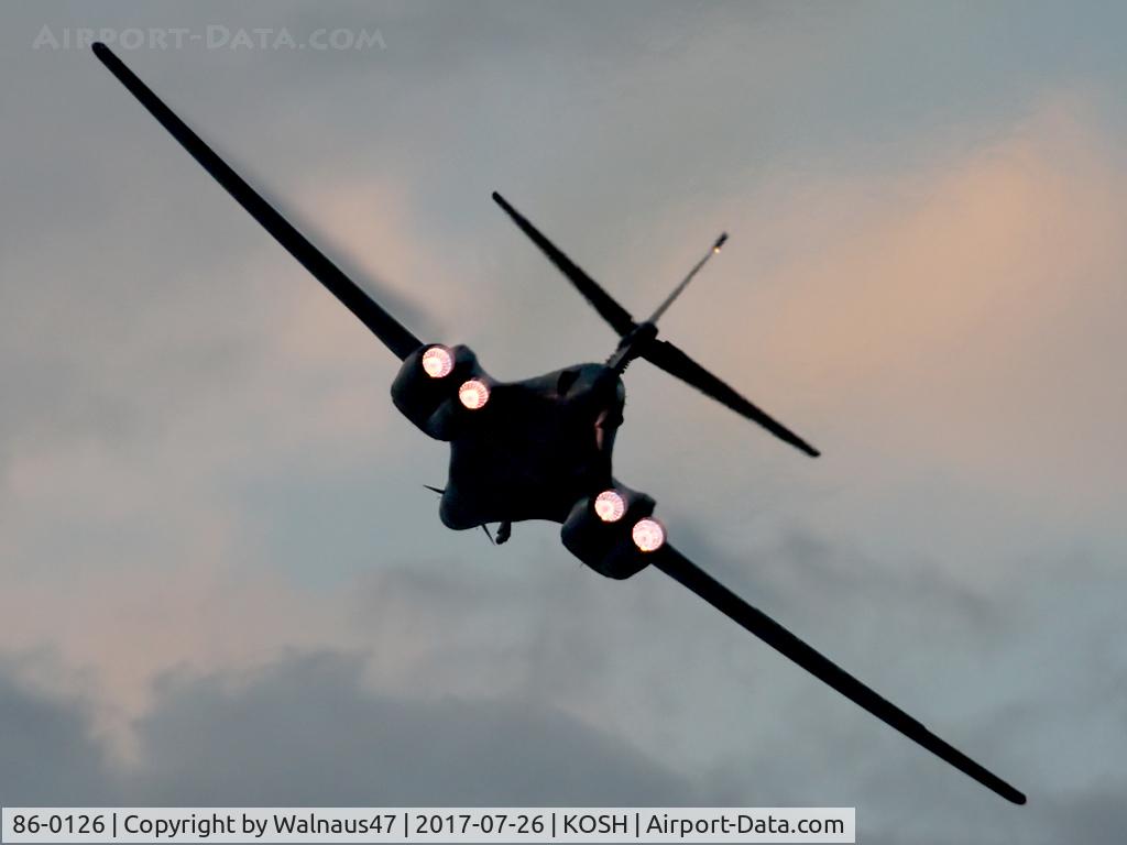 86-0126, 1986 Rockwell B-1B Lancer C/N 86, Rear view of USAF B-1B AF 86-0126 Cn 86 starting a Dusk ‘Afterburner Vapour Run’, with wings swept forward. Photo taken at the start of the Night Airshow, at Air Venture Oshkosh KOSH on 26Jul2017. Vapour forms on the wings as the aircraft accelerated.